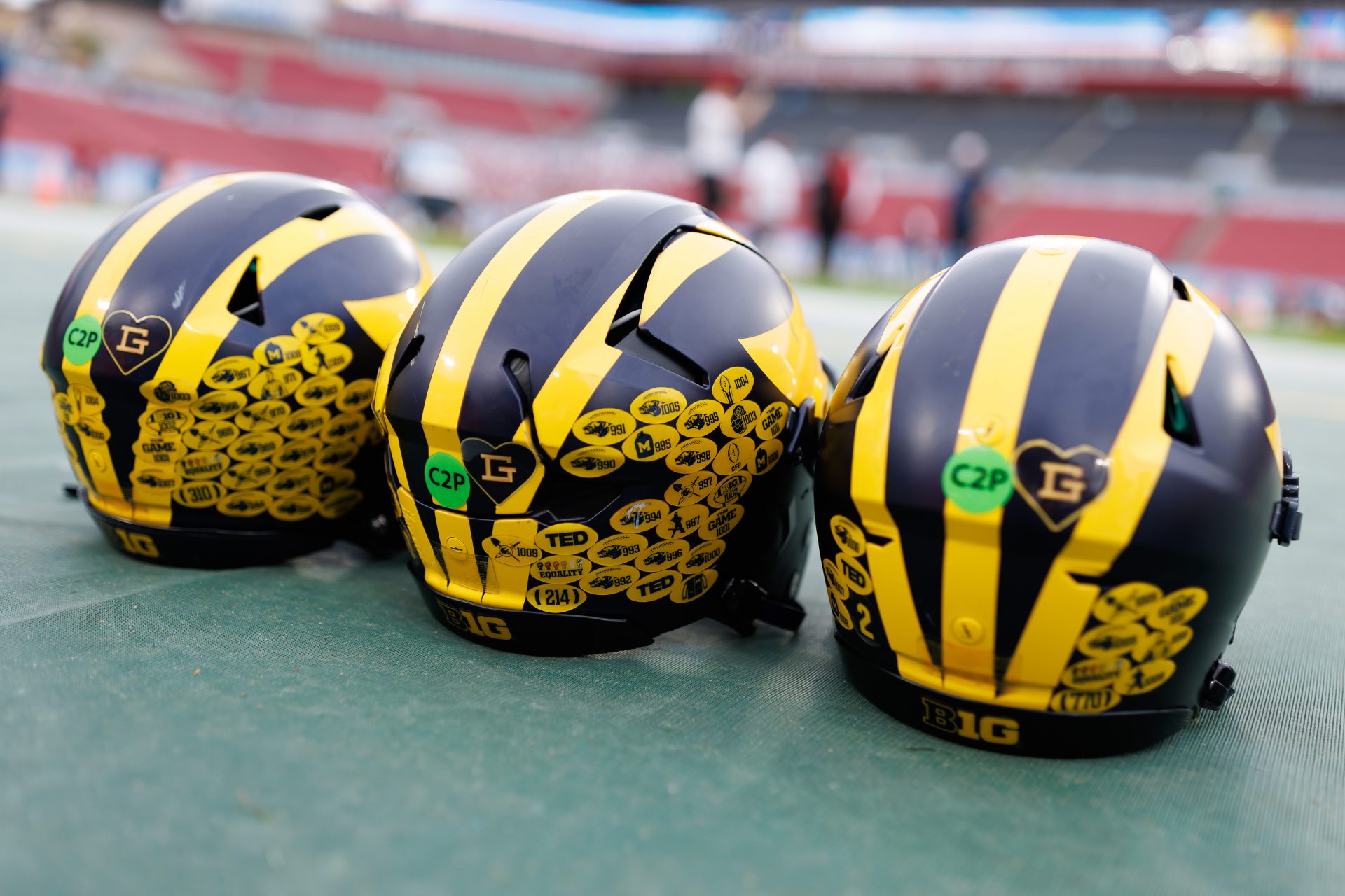 Michigan Wolverines quarterback helmets sit on the field before a game against the Alabama Crimson Tide at Raymond James Stadium.
