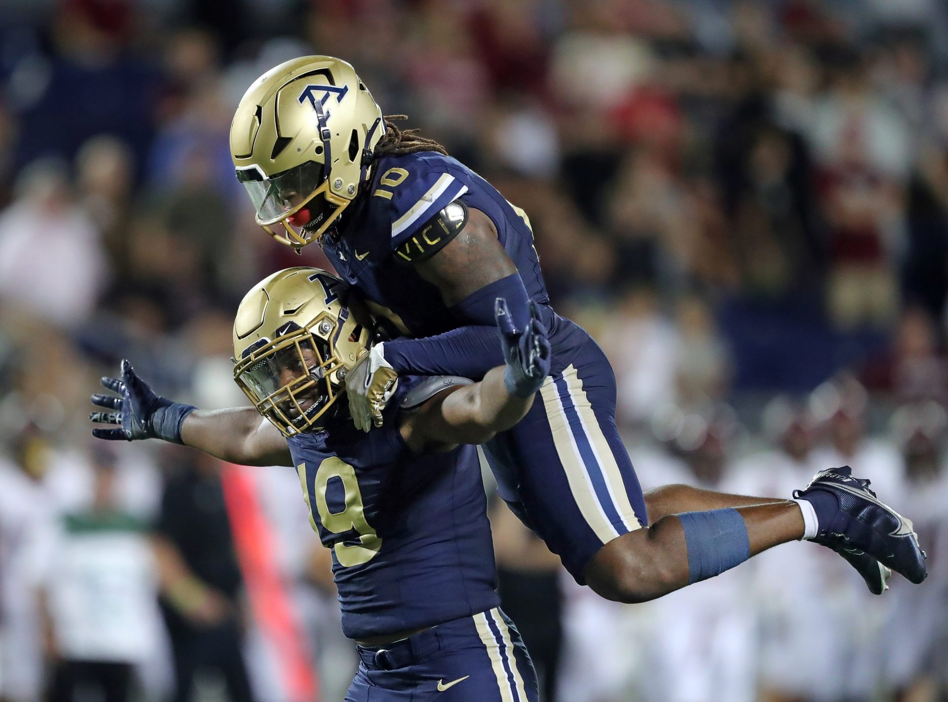Akron Zips defensive lineman CJ Nunnally IV, bottom, celebrates his strip-sack with linebacker Antavious Fish to seal the win for Akron late in an NCAA college football game against Colgate, Saturday, Sept. 14, 2024, in Akron, Ohio.
