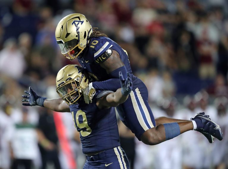 Akron Zips defensive lineman CJ Nunnally IV, bottom, celebrates his strip-sack with linebacker Antavious Fish to seal the win for Akron late in an NCAA college football game against Colgate, Saturday, Sept. 14, 2024, in Akron, Ohio.