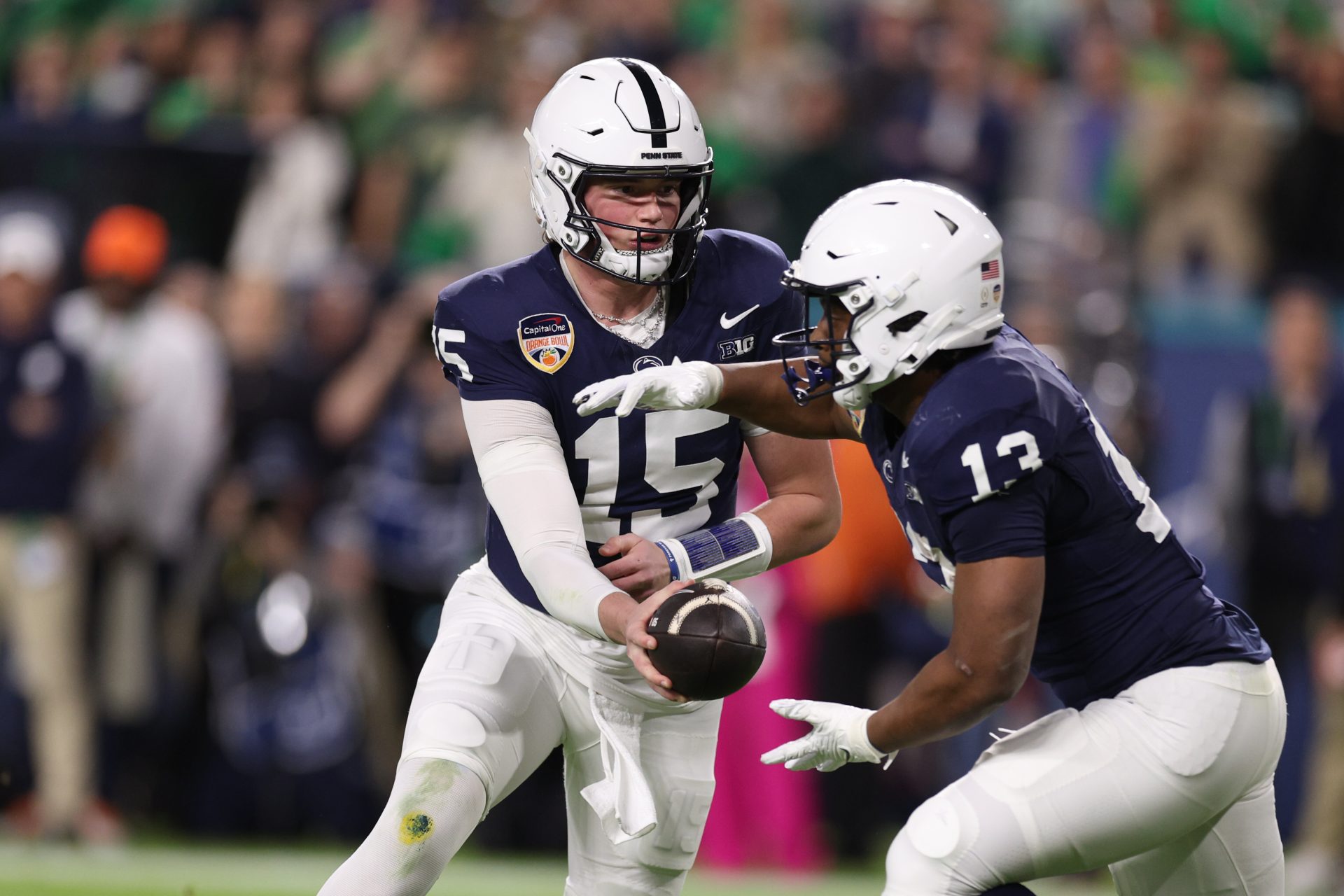 Penn State Nittany Lions quarterback Drew Allar (15) hands the ball to Penn State Nittany Lions running back Kaytron Allen (13) in the first half against the Notre Dame Fighting Irish in the Orange Bowl at Hard Rock Stadium.