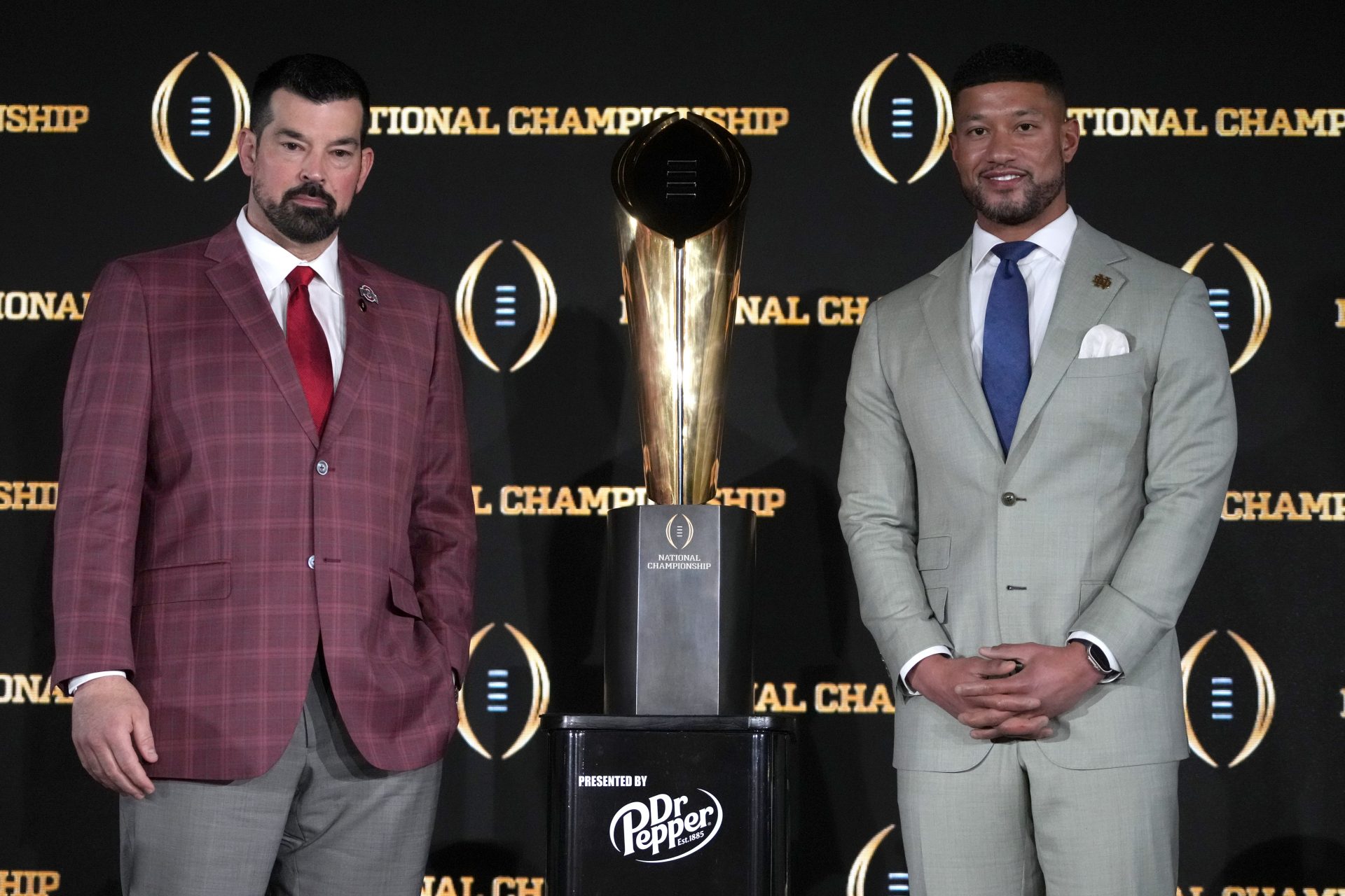 Ohio State Buckeyes head coach Ryan Day (left) and Notre Dame Fighting Irish head coach Marcus Freeman pose with the College Football Playoff National Championship trophy at press conference at The Westin Peachtree Plaza, Savannah Ballroom.