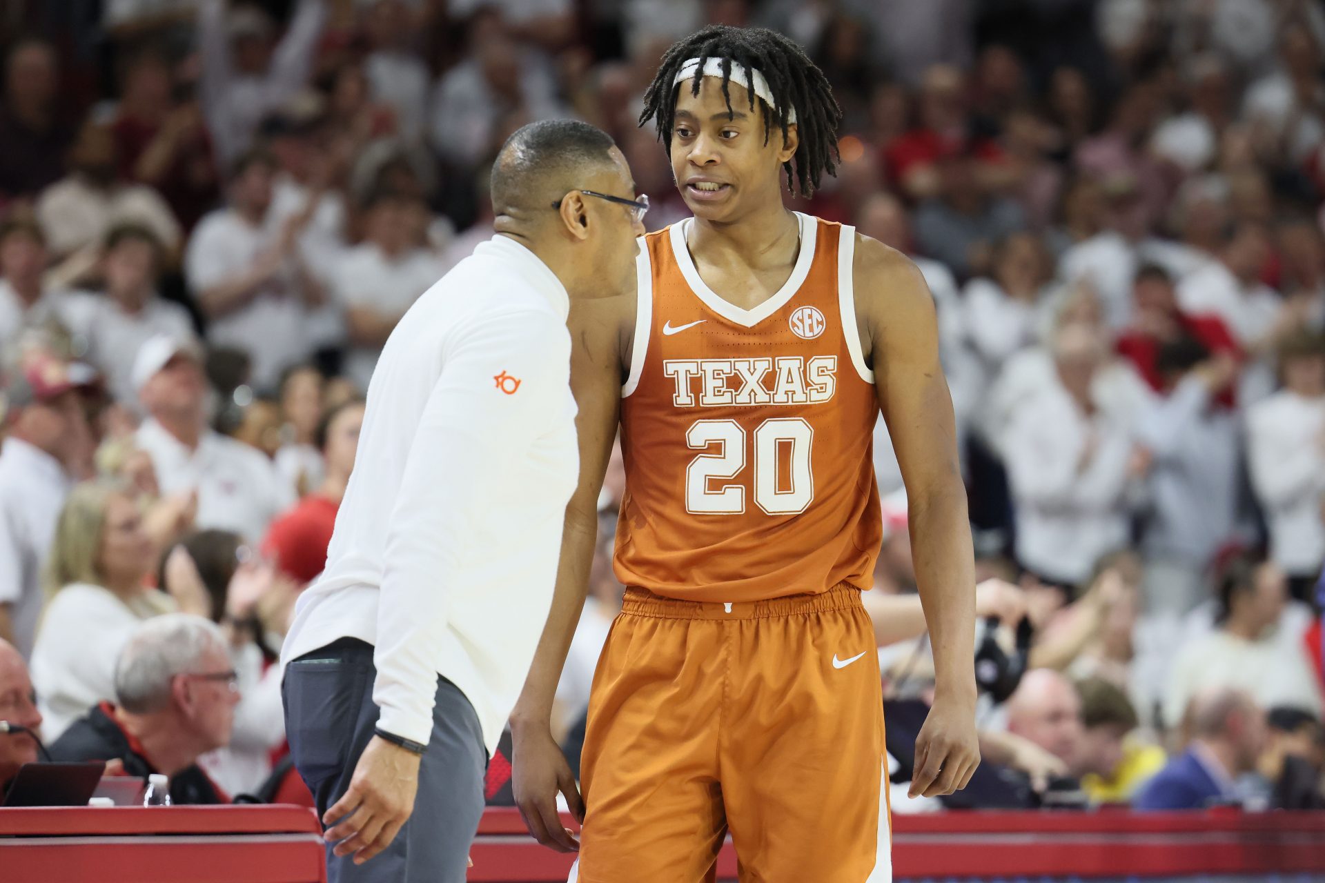 Texas Longhorns guard Tre Johnson (20) talks to head coach Rodney Terry during overtime against the Arkansas Razorbacks at Bud Walton Arena.