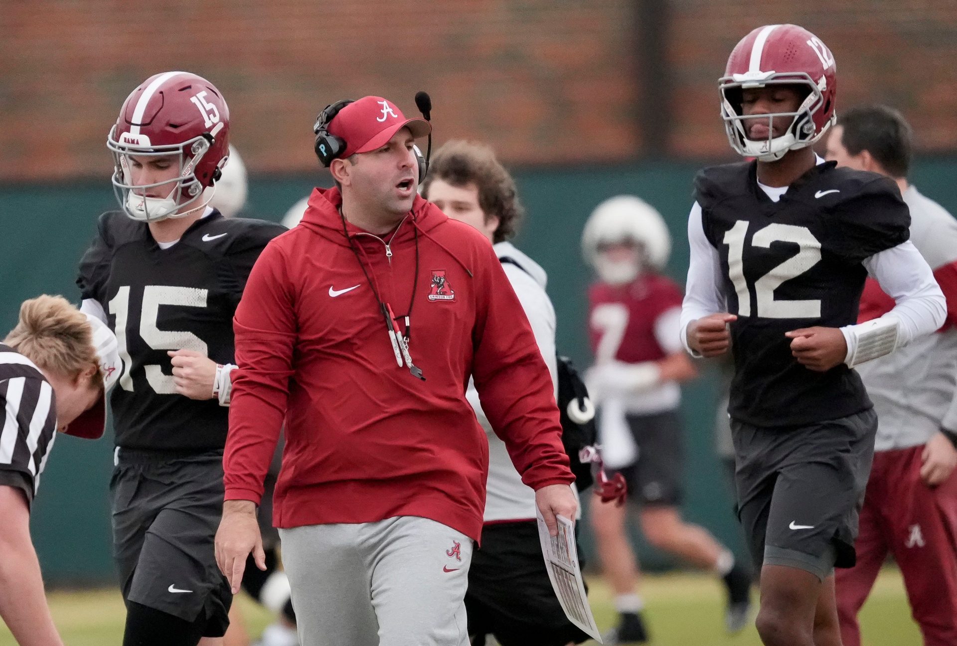 Quarterbacks coach Nick Seridan walks between quarterbacks Ty Simpson (15) and Keelon Russell (12)during Spring Practice for the Crimson Tide.