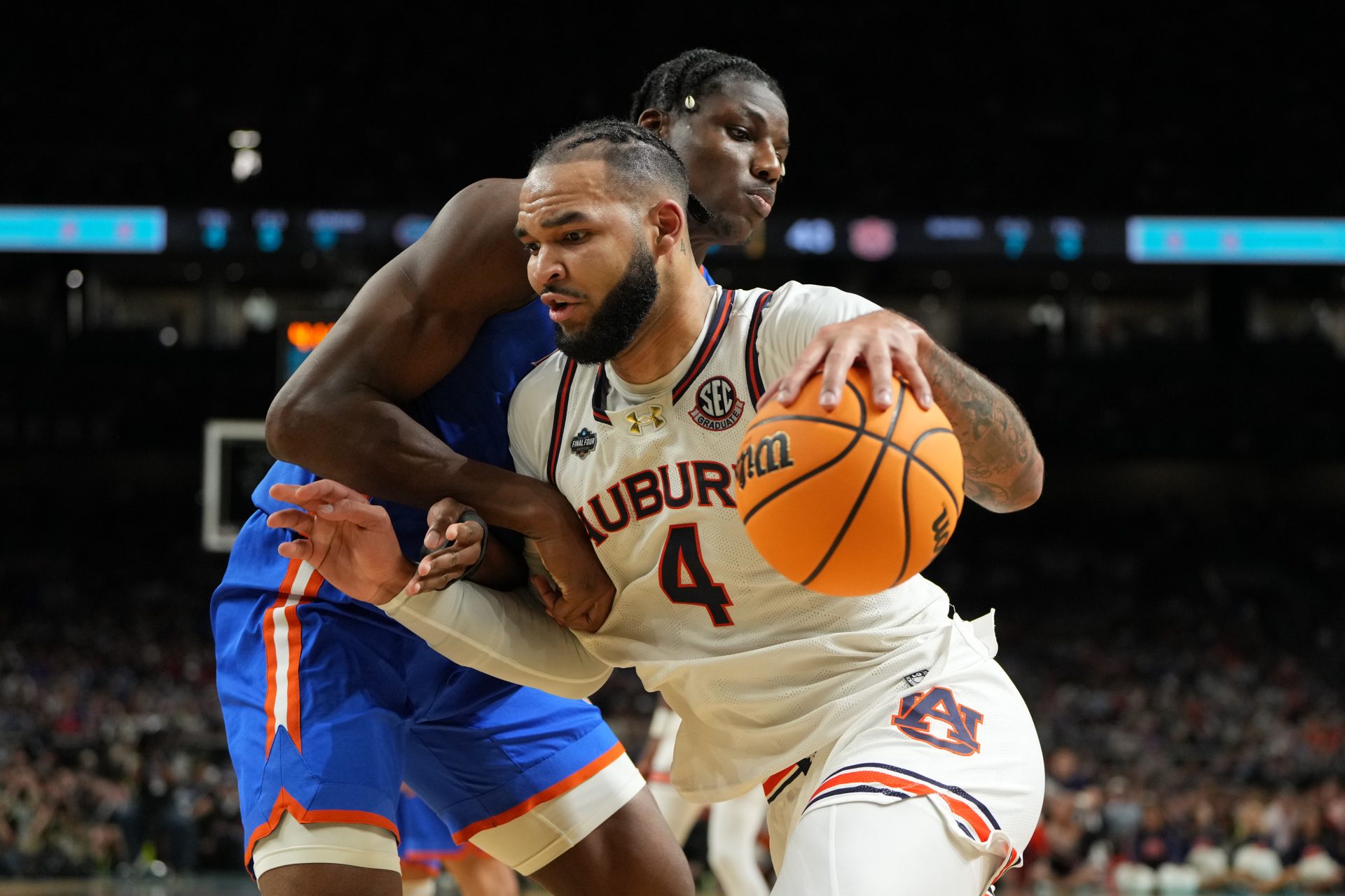 Auburn Tigers forward Johni Broome (4) drives to the basket against Florida Gators center Rueben Chinyelu (9) during the first half in the semifinals of the men's Final Four of the 2025 NCAA Tournament at the Alamodome.