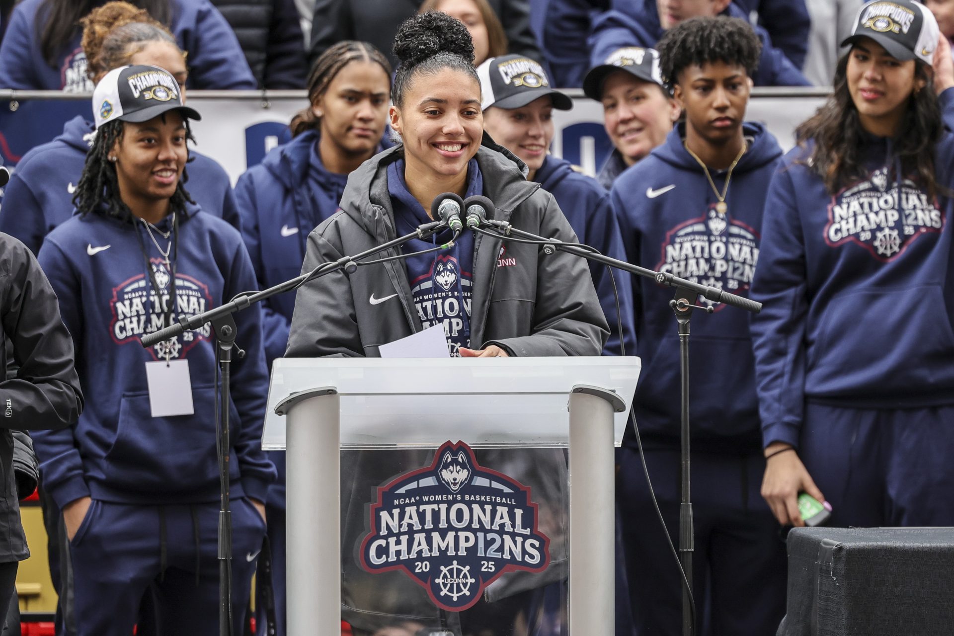 UConn student-athlete Azzi Fudd addresses the crowd while her teammates UConn student-athletes Paige Bueckers,  KK Arnold, Sarah Strong  and Ayanna Patterson look on during the Final Four champions victory parade and rally outside of the XL Center in Hartford, CT.
