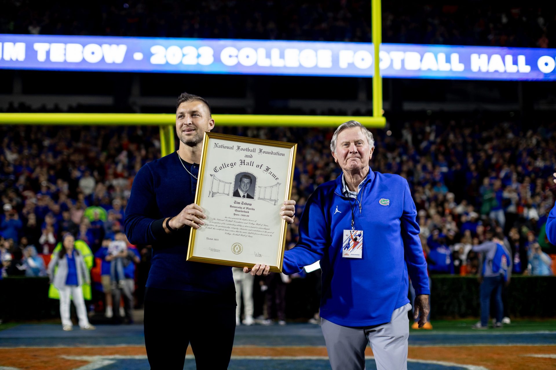 Former Florida Gators quarterback Tim Tebow receives the College Hall of Fame award from Florida Gators quarterback Steve Spurrier during the first half against the Florida State Seminoles at Steve Spurrier Field at Ben Hill Griffin Stadium in Gainesville, FL on Saturday, November 25, 2023. [Matt Pendleton/Gainesville Sun]