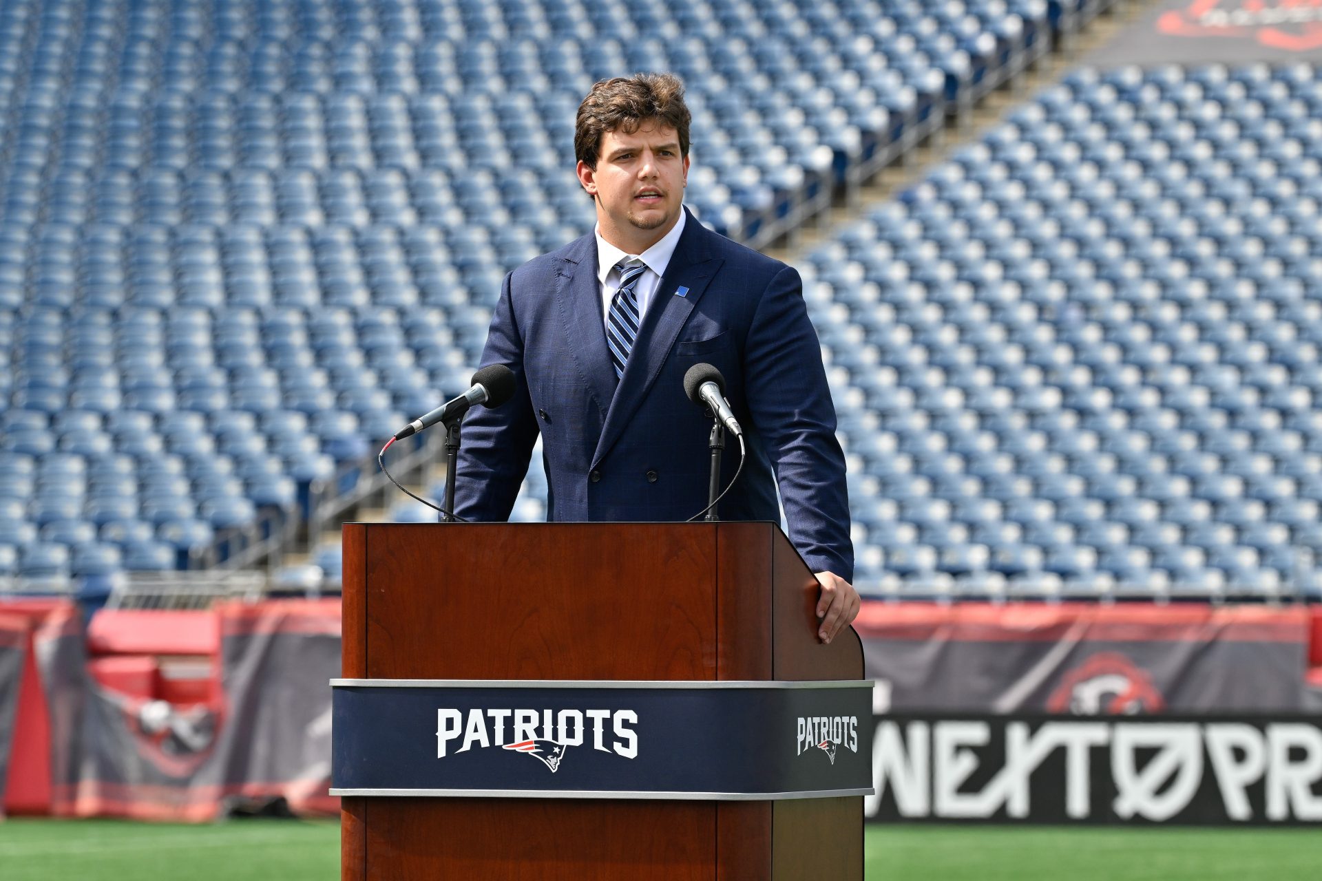 New England Patriots first round draft pick Will Campbell addresses media during a press conference on the game field at Gillette Stadium.