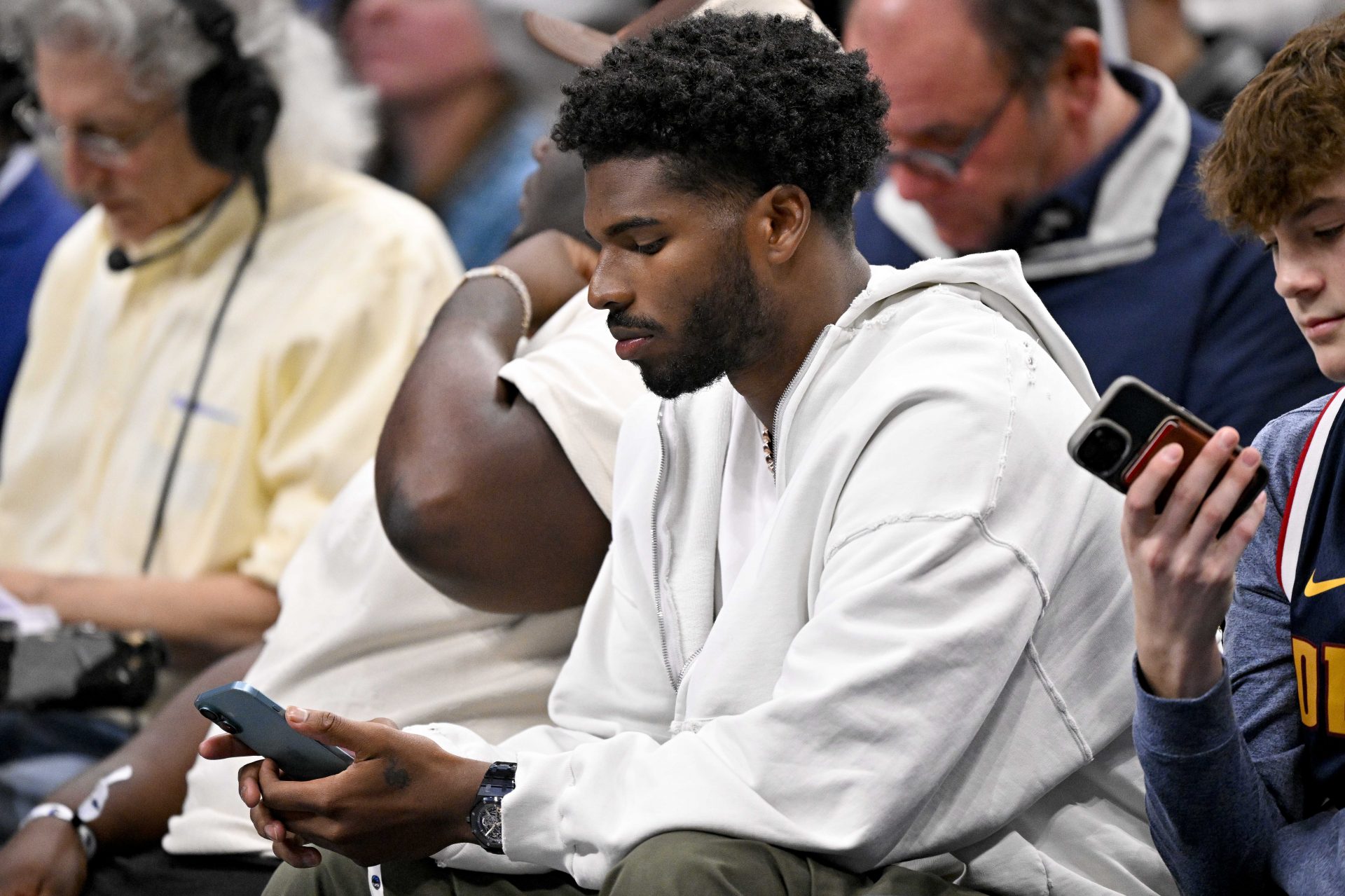 Colorado Buffaloes quarterback Shedeur Sanders checks his phone during the game between the Dallas Mavericks and the Denver Nuggets in the second quarter at the American Airlines Center.
