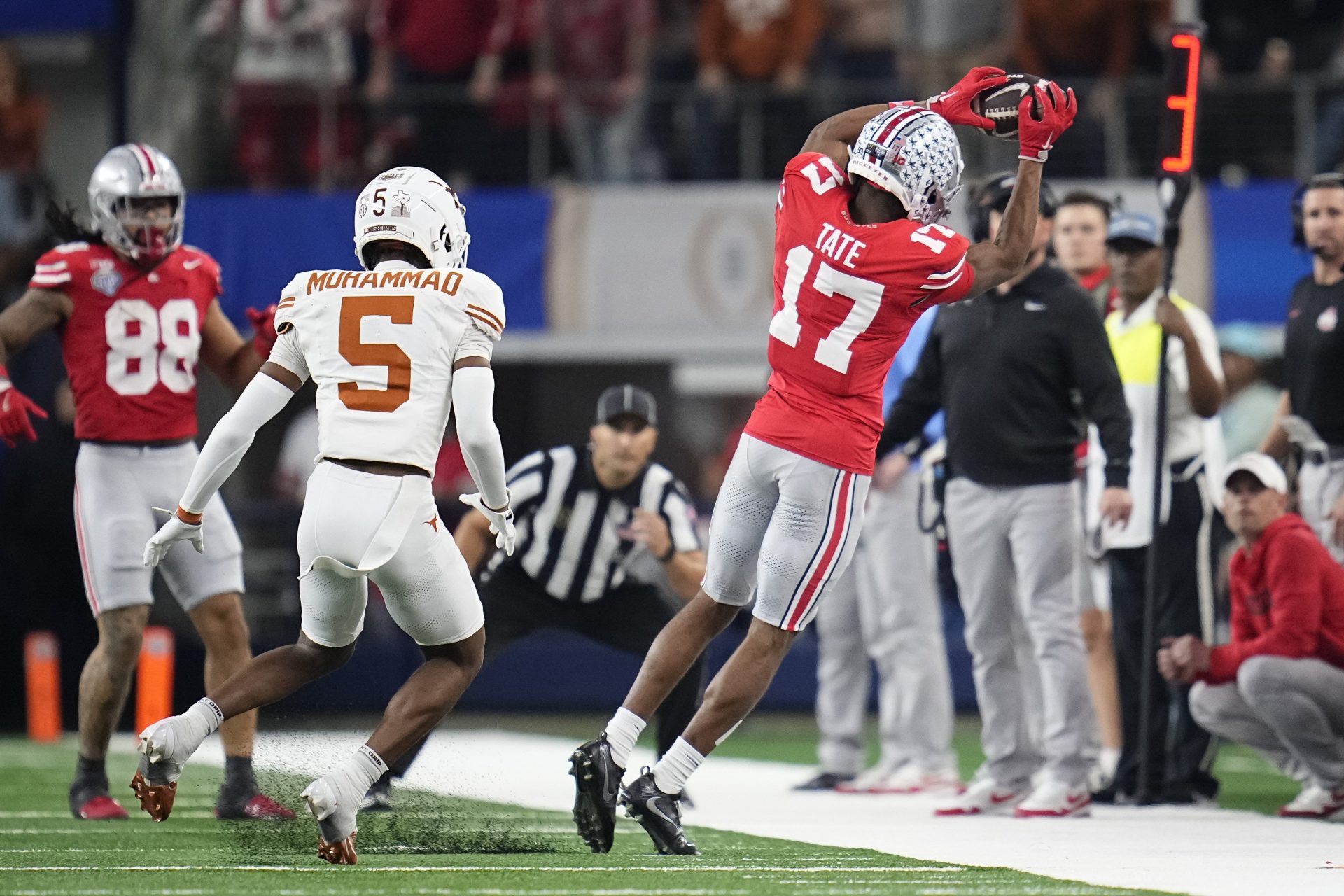 Ohio State Buckeyes wide receiver Carnell Tate (17) makes a sideline catch in front of Texas Longhorns defensive back Malik Muhammad (5) during the first half of the Cotton Bowl Classic College Football Playoff semifinal game at AT&T Stadium in Arlington, Texas on Jan. 10, 2025.