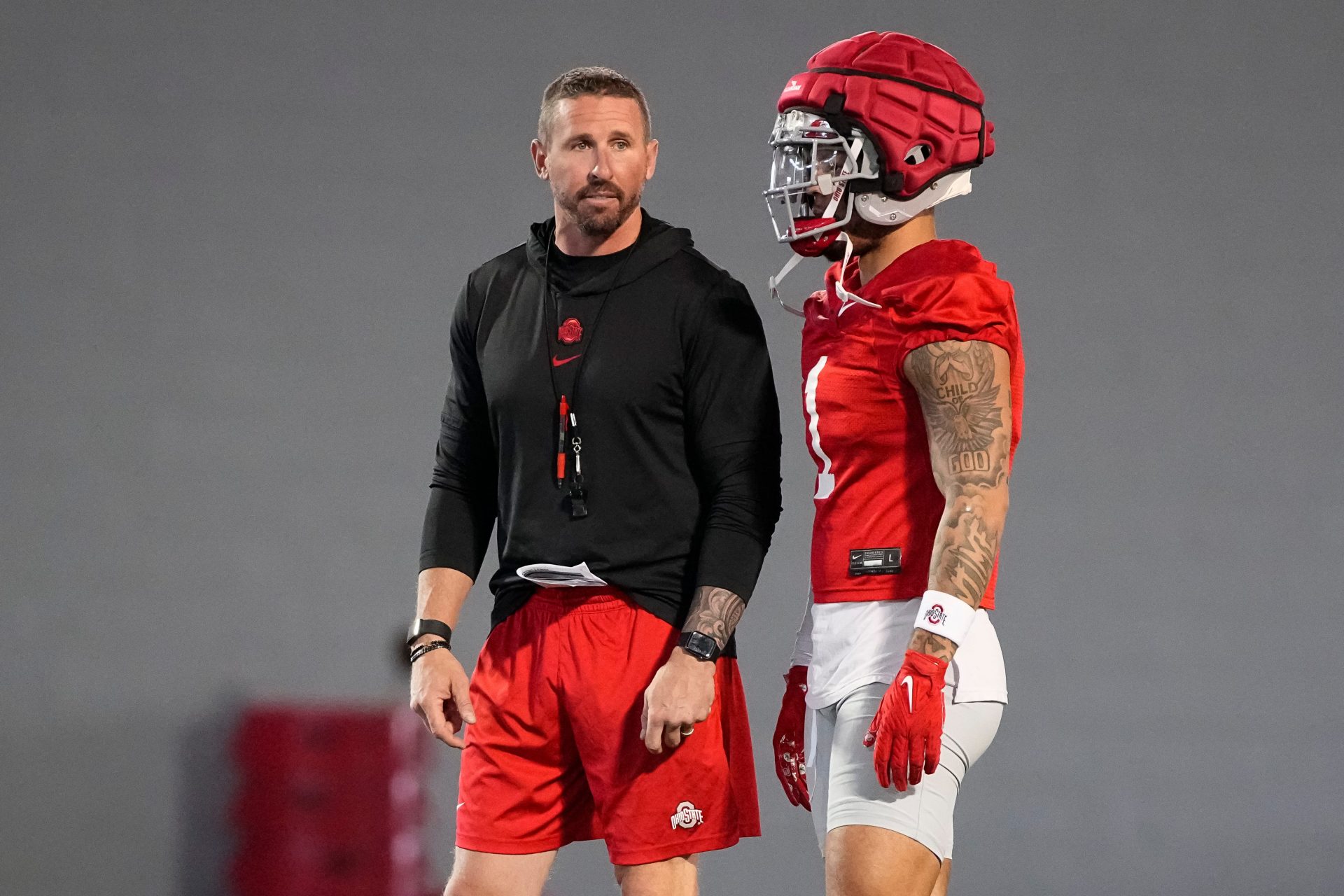 Ohio State Buckeyes offensive coordinator Brian Hartline talks to wide receiver Brandon Inniss (1) during spring football practice