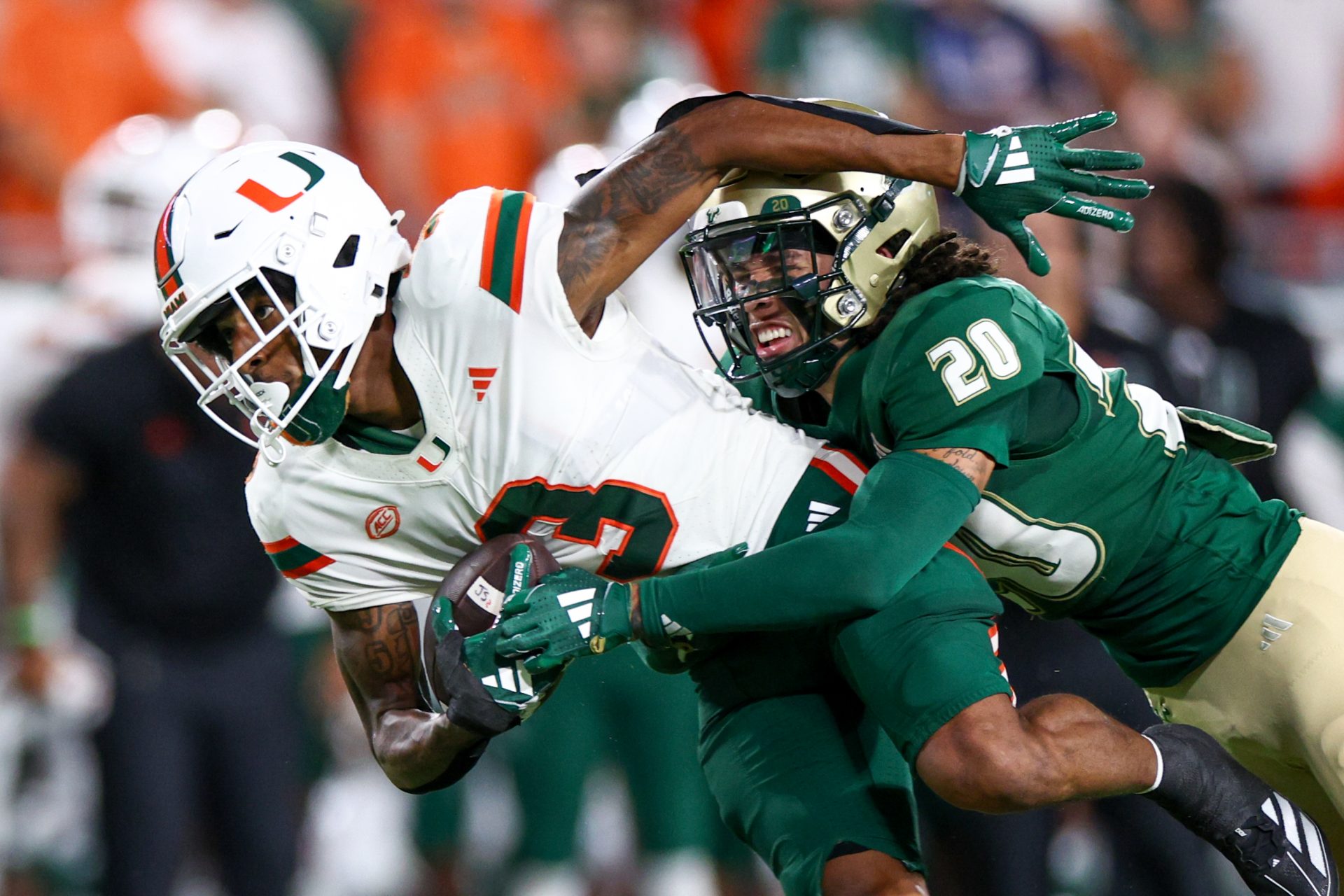 Miami Hurricanes wide receiver Jacolby George (3) is tackled by South Florida Bulls cornerback Brent Austin (20) in the first quarter at Raymond James Stadium.