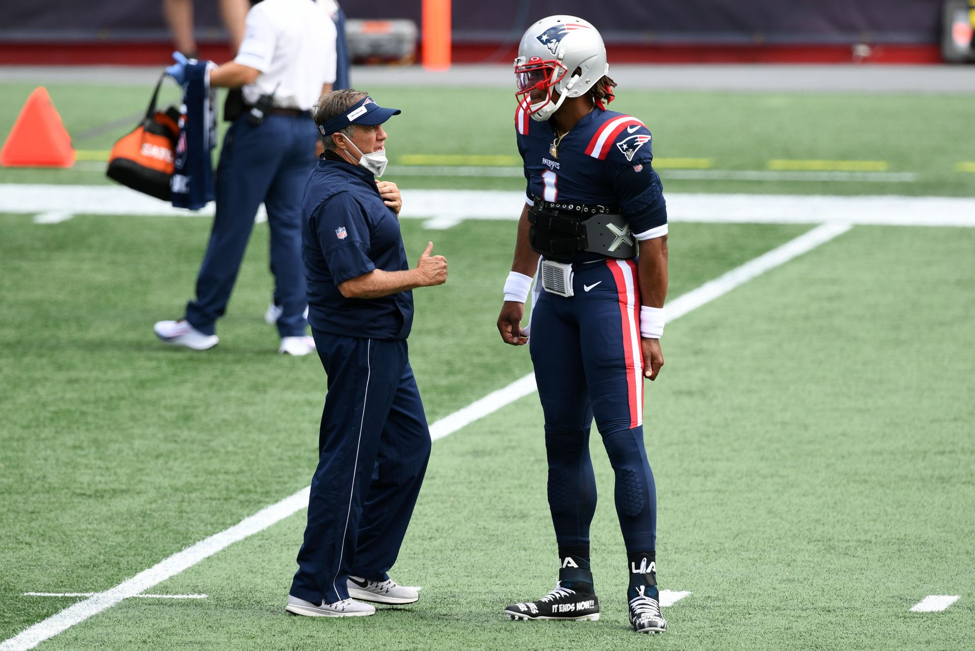 New England Patriots head coach Bill Belichick talks with quarterback Cam Newton (1) before a game against the Miami Dolphins at Gillette Stadium.