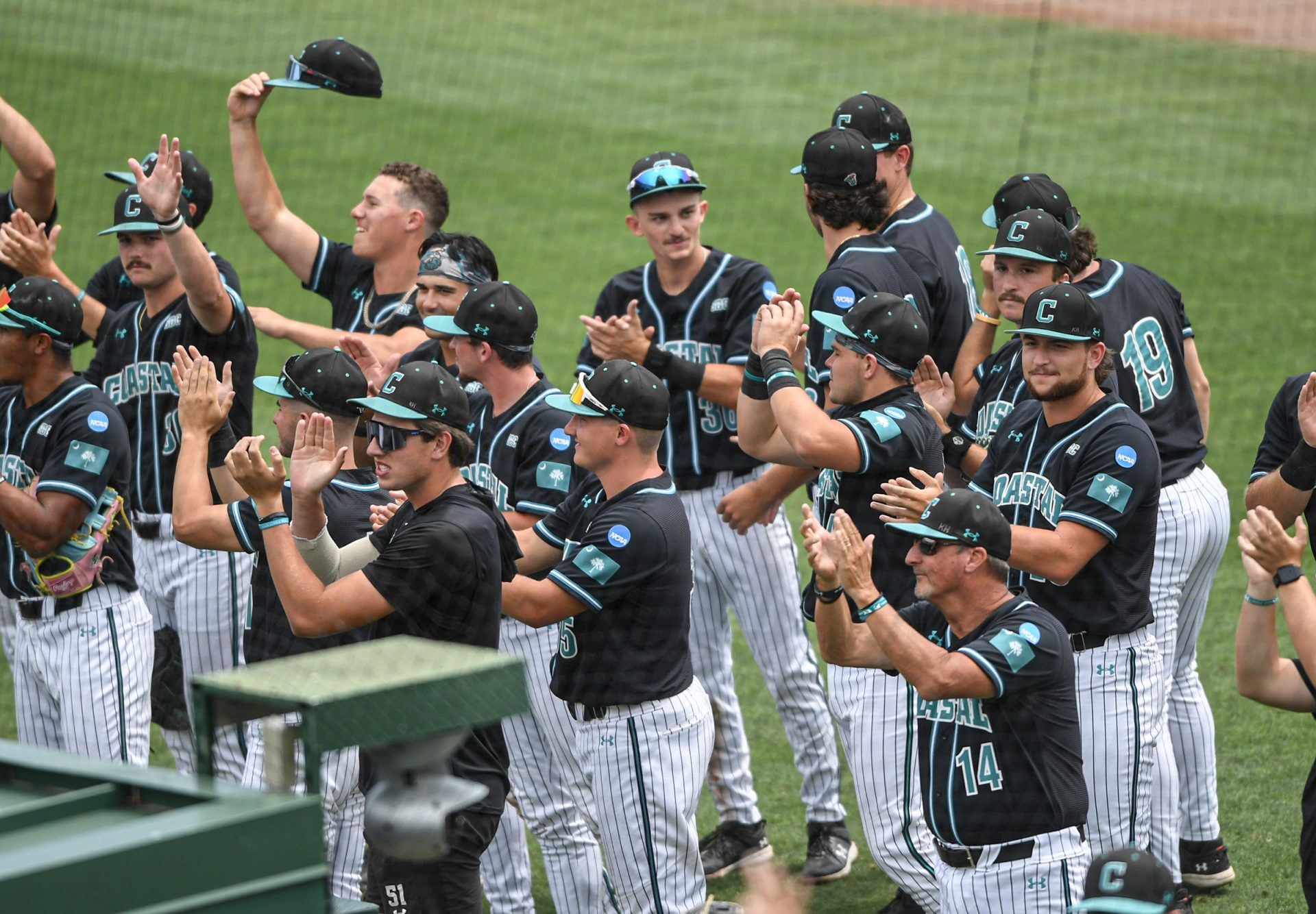 Coastal Carolina University Head Coach Gary Gilmore, right, claps with players after the winning the the NCAA Clemson Regional baseball game against Vanderbilt at Doug Kingsmore Stadium.