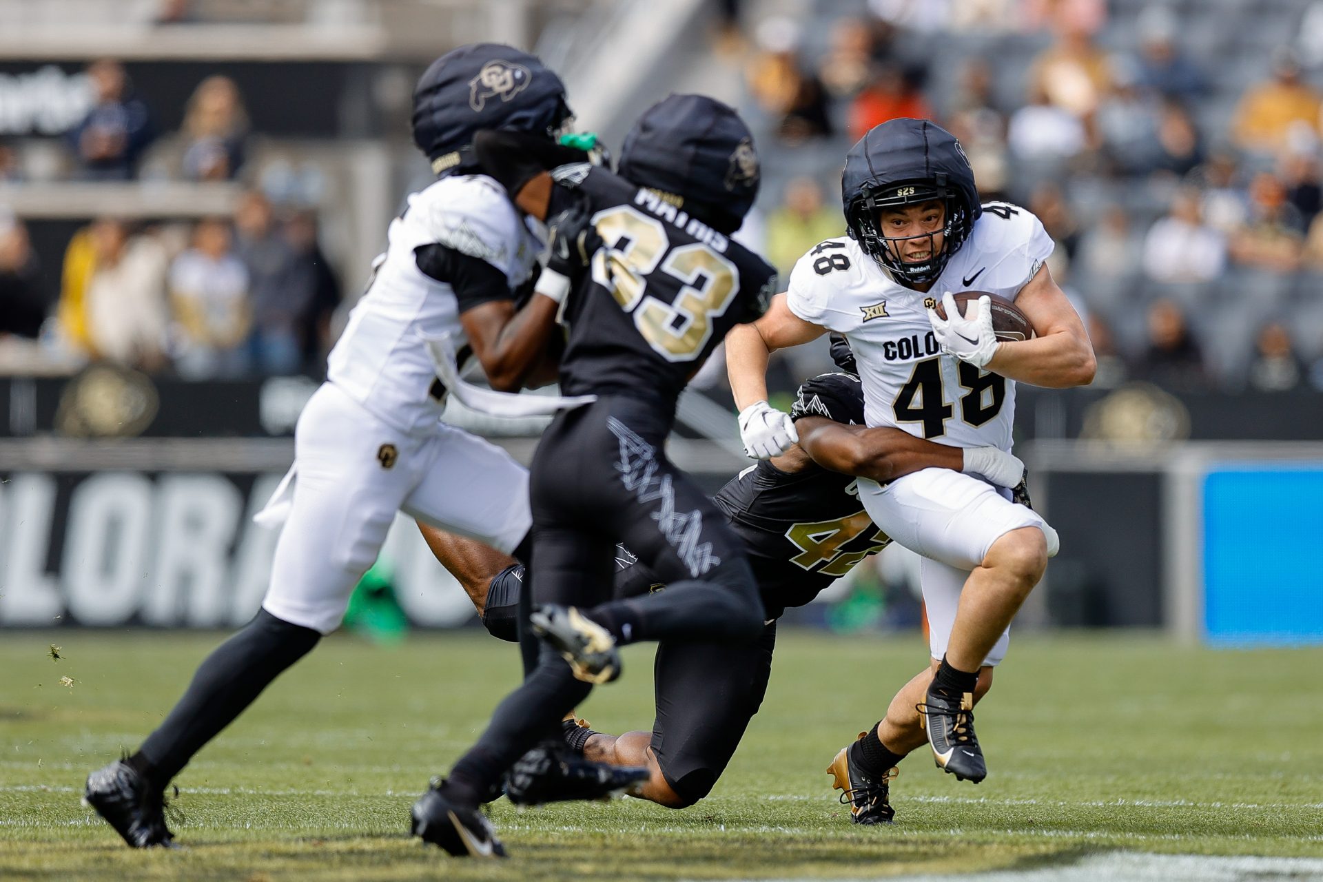 Colorado Buffaloes running back Christian Sarem (48) is tackled by inside linebacker Jeremiah Brown (42) as wide receiver Quentin Gibson (15) defends against cornerback Kole Mathis (33) during the spring game at Folsom Field.