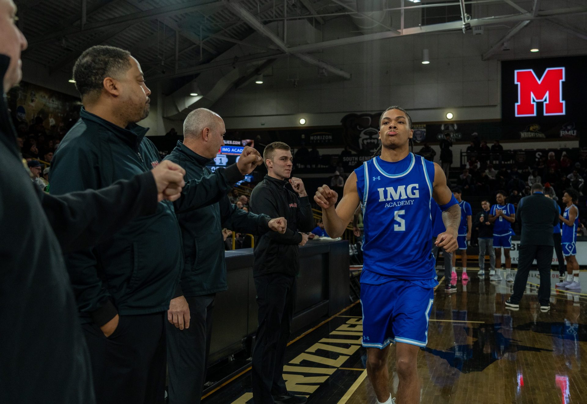IMG Academy’s Darius Acuff (5) fist bumps members of the Orchard Lake Saint Mary’s coaching staff before the game