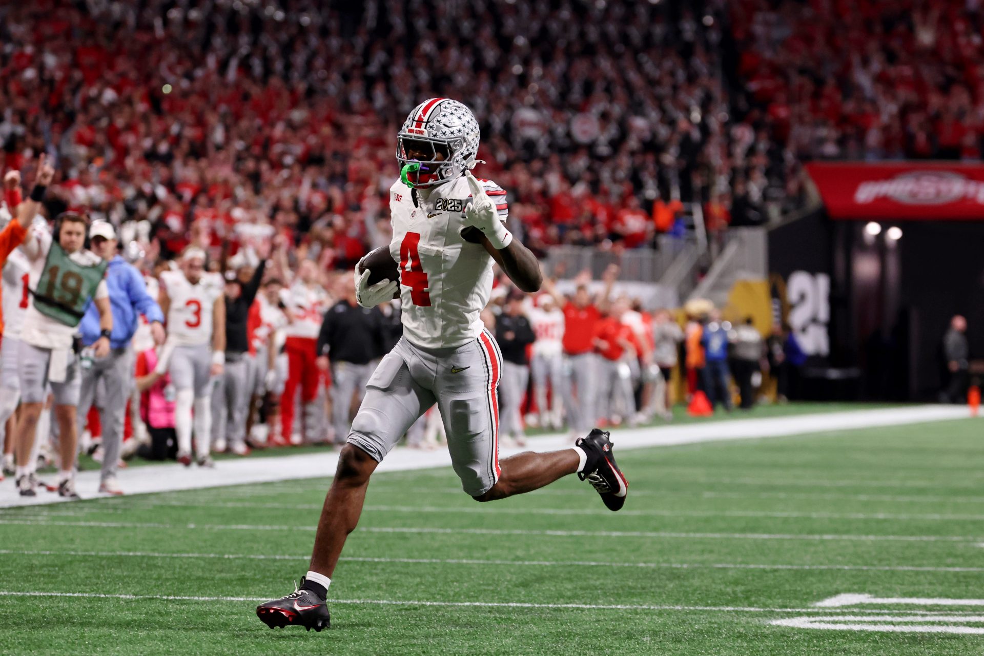 Ohio State Buckeyes wide receiver Jeremiah Smith (4) runs with the ball for a touchdown during the first half the CFP National Championship college football game at Mercedes-Benz Stadium.