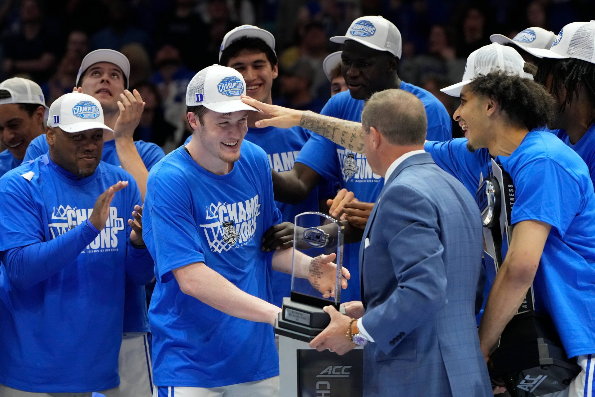 Duke Blue Devils guard Kon Knueppel (7) recieves the MVP trophy from ACC commissioner Jim Phillips as guard Tyrese Proctor (5) pats him on the head during the cmampionship celebration after the 2025 ACC Conference Championship game at Spectrum Center.