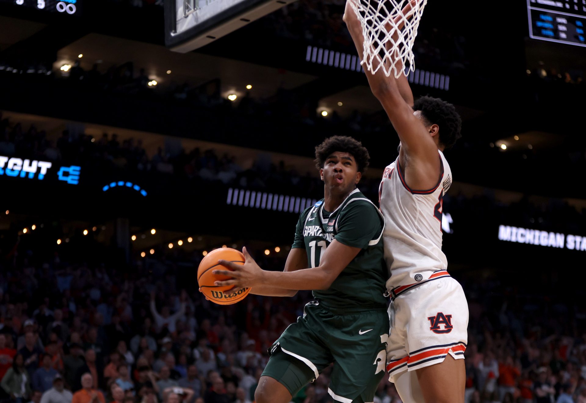 Michigan State Spartans guard Jase Richardson (11) drives against Auburn Tigers center Dylan Cardwell (44) during the second half in the South Regional final of the 2025 NCAA tournament at State Farm Arena.