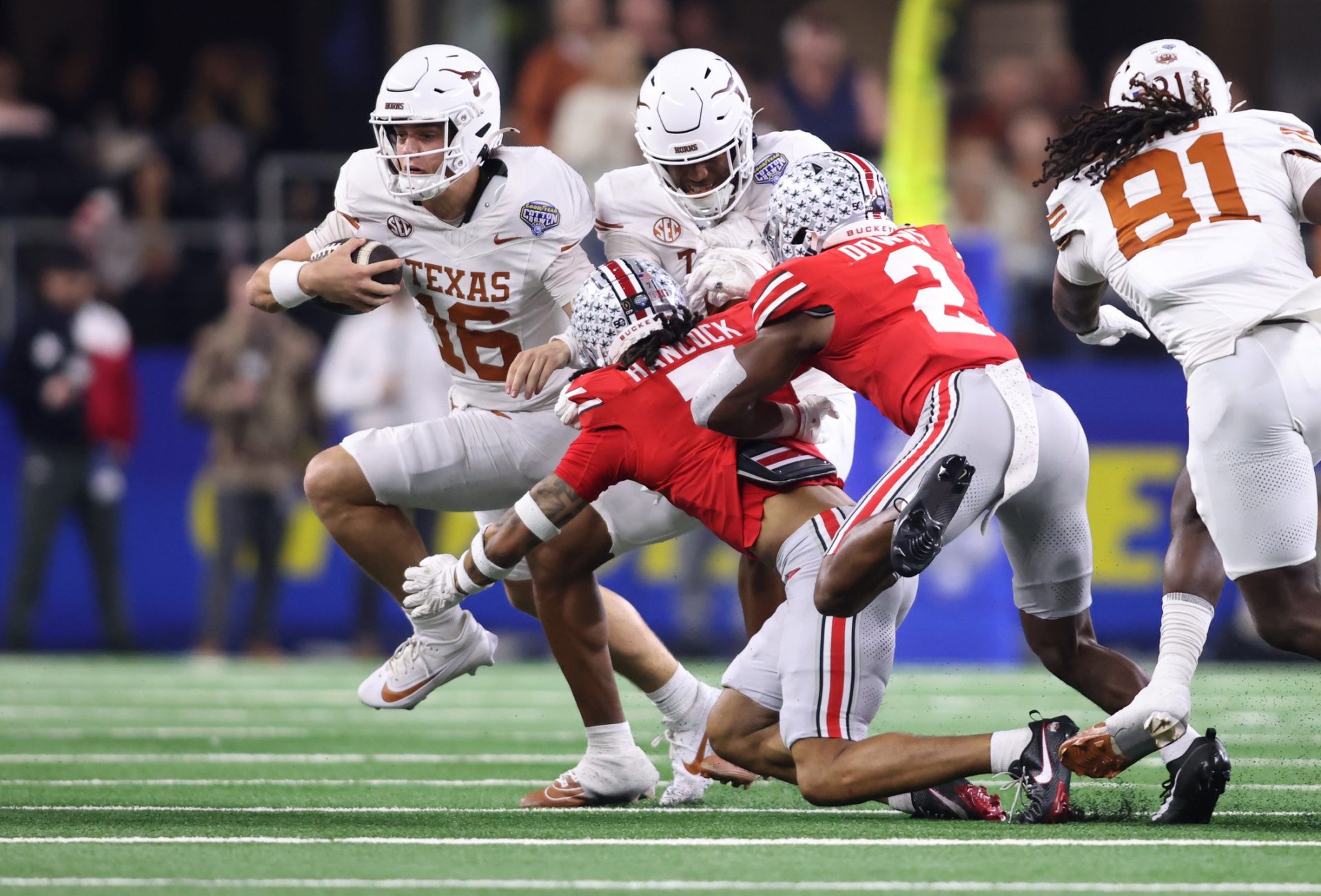 Texas Longhorns quarterback Arch Manning (16) runs against Ohio State Buckeyes cornerback Jordan Hancock (7) and safety Caleb Downs (2) during the second quarter of the College Football Playoff semifinal in the Cotton Bowl at AT&T Stadium.