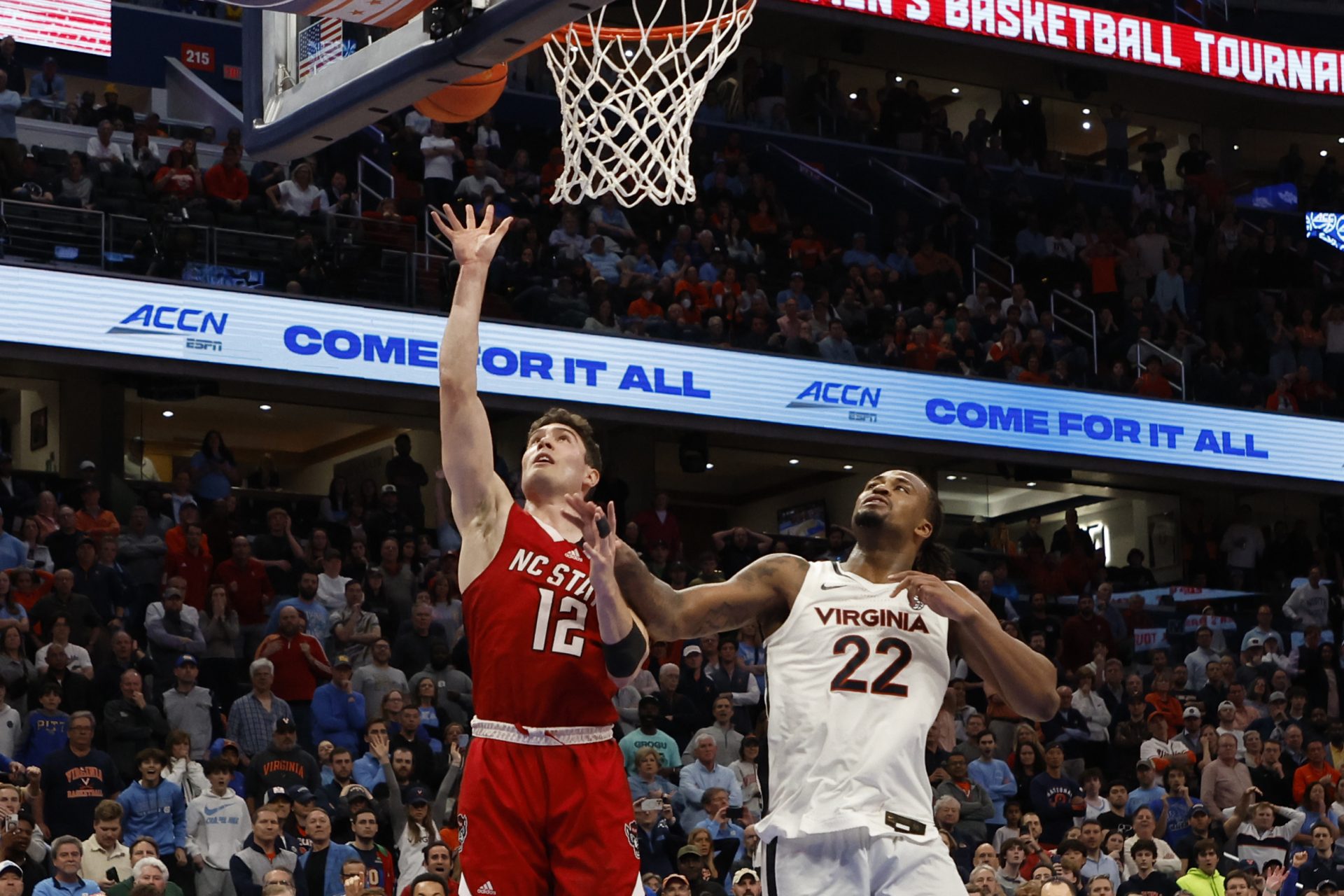 North Carolina State Wolfpack guard Michael O'Connell (12) shoots the ball as Virginia Cavaliers forward Jordan Minor (22) defends in overtime at Capital One Arena.