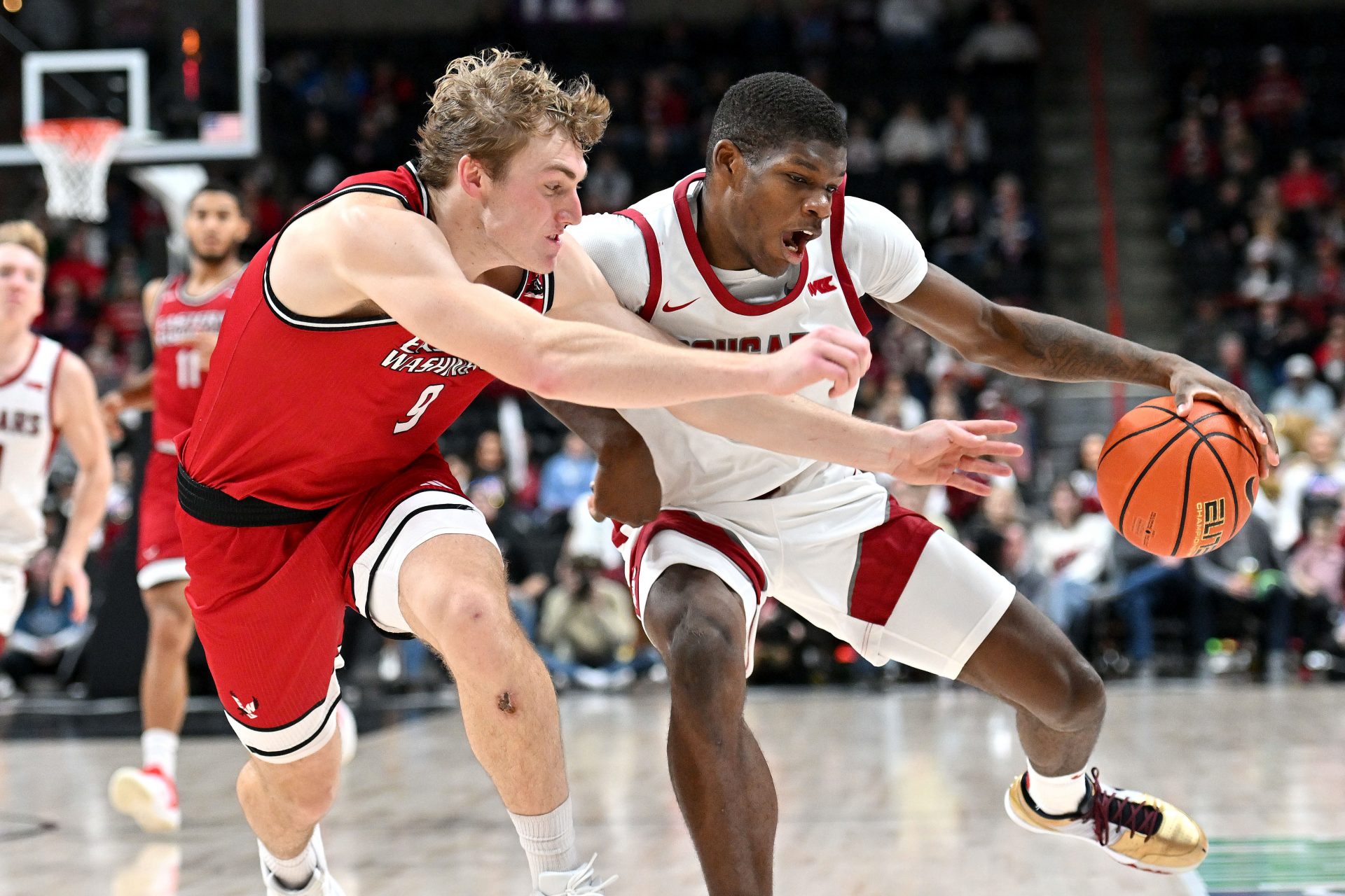 Washington State Cougars guard Cedric Coward (0) controls the ball against Eastern Washington Eagles guard Andrew Cook (9) in the first half at Spokane Veterans Memorial Arena.
