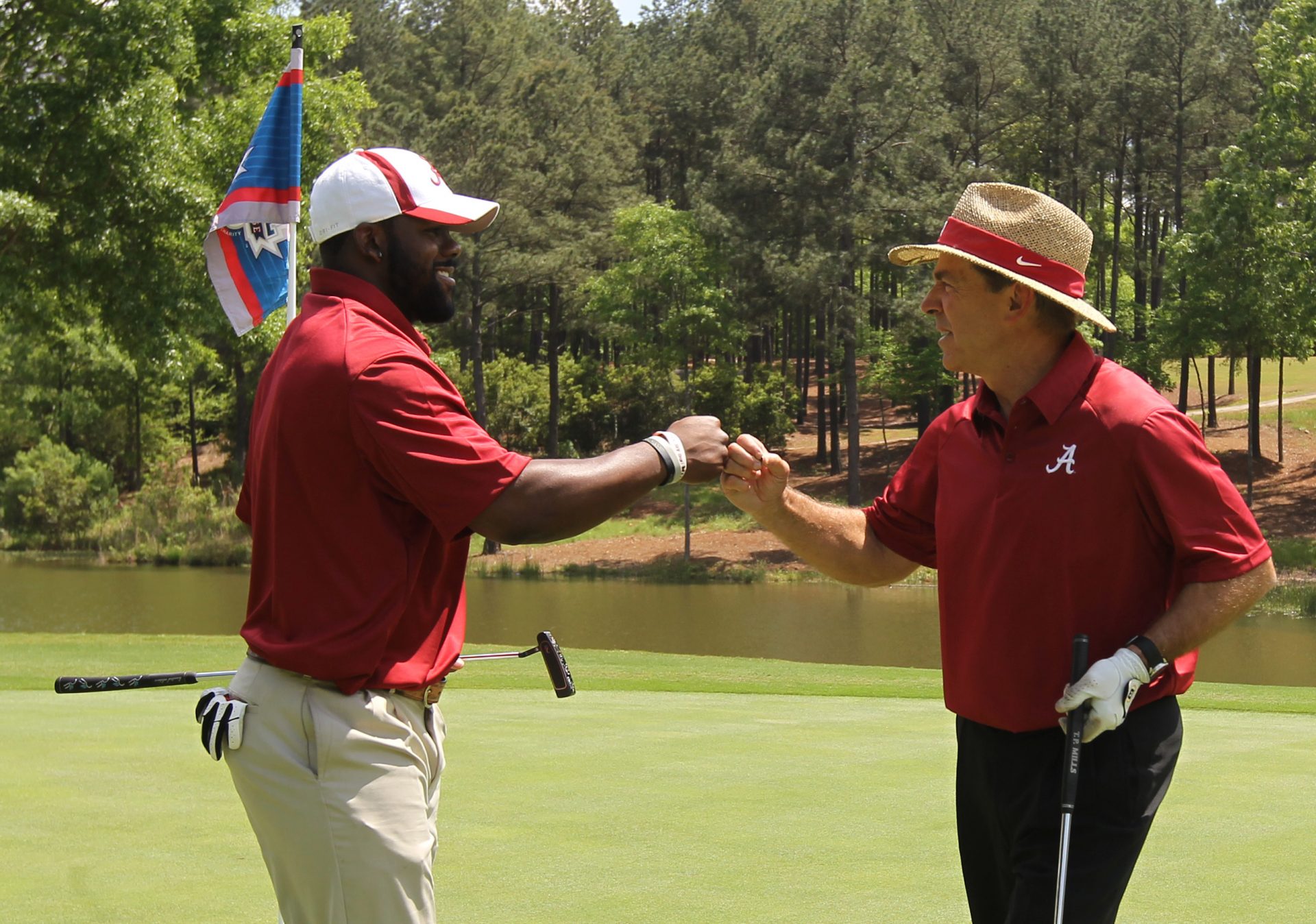 Alabama Crimson Tide head football coach Nick Saban (right) and Alabama Crimson Tide former football player Mark Ingram fist bump during the Chick-fil-A Challenge at the Reynolds Plantation Resort.