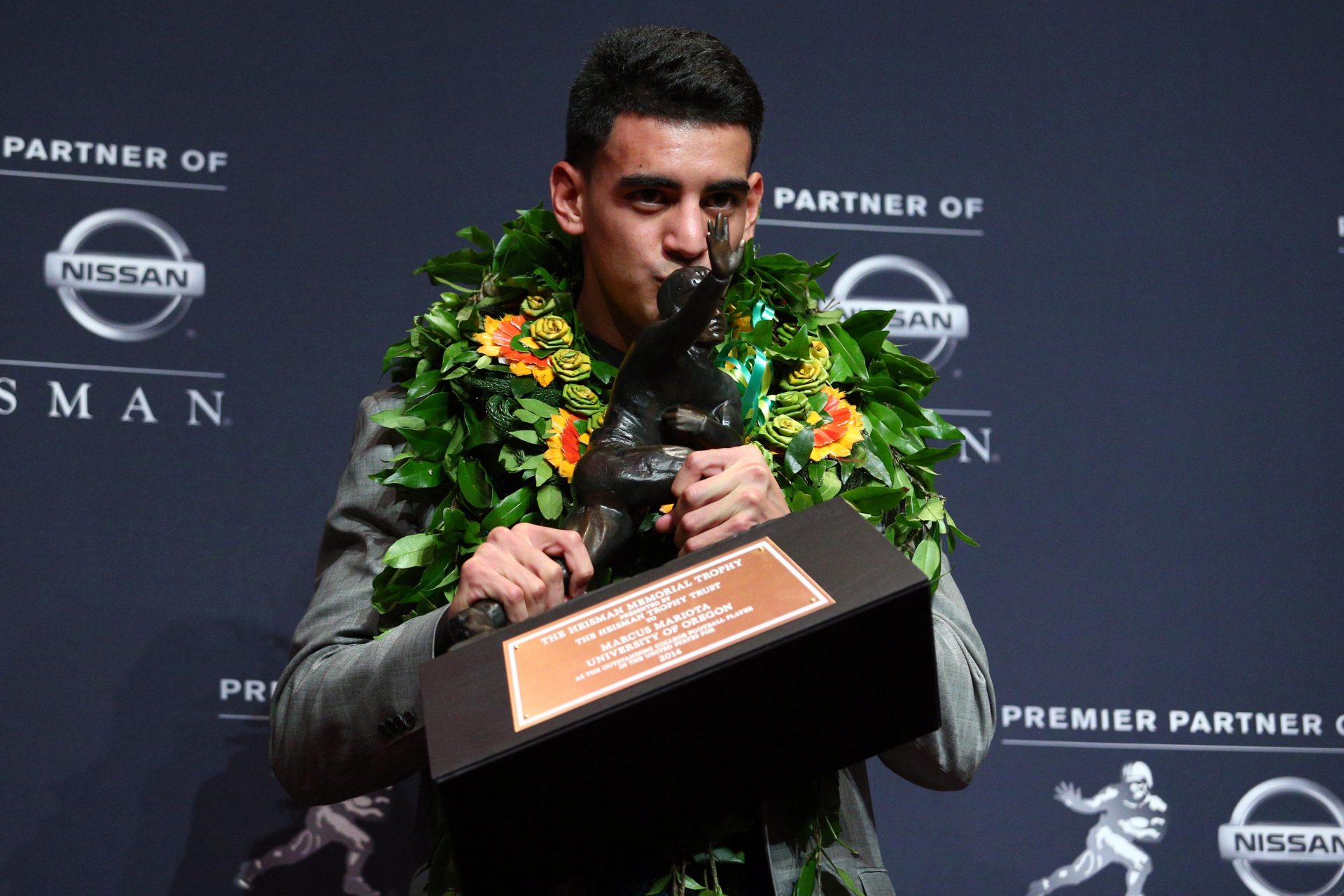 Oregon Ducks quarterback Marcus Mariota kisses the Heisman Trophy during a press conference at the New York Marriott Marquis after winning the Heisman Trophy.