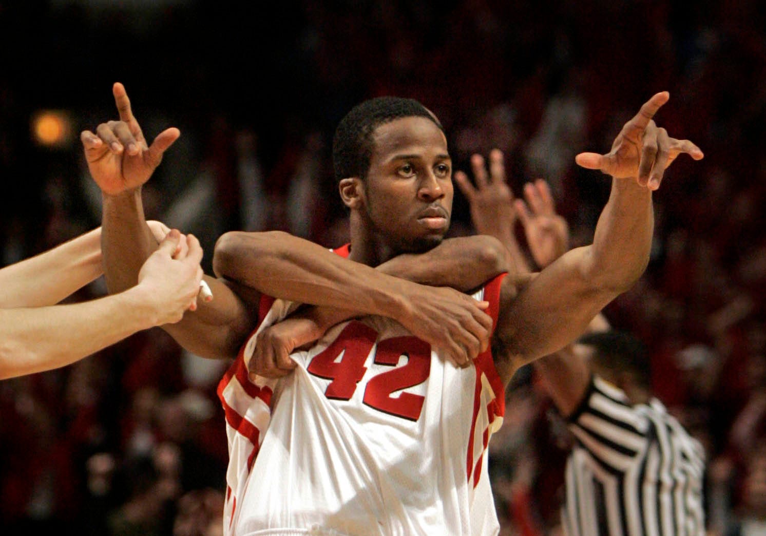 Badgers forward Alando Tucker is mobbed by fellow player Sharif Chambliss as he points to the crowd after hitting a game winning three point show with under 4 seconds left in the game to beat Iowa,