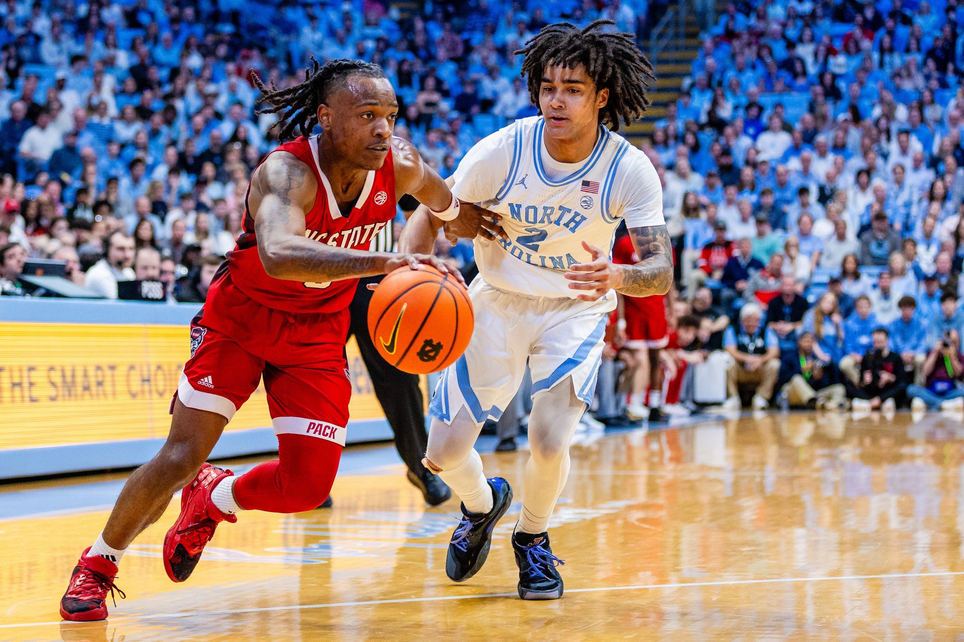 North Carolina State Wolfpack guard DJ Horne (0) drives past North Carolina Tar Heels guard Elliot Cadeau (2) during the first half at Dean E. Smith Center.