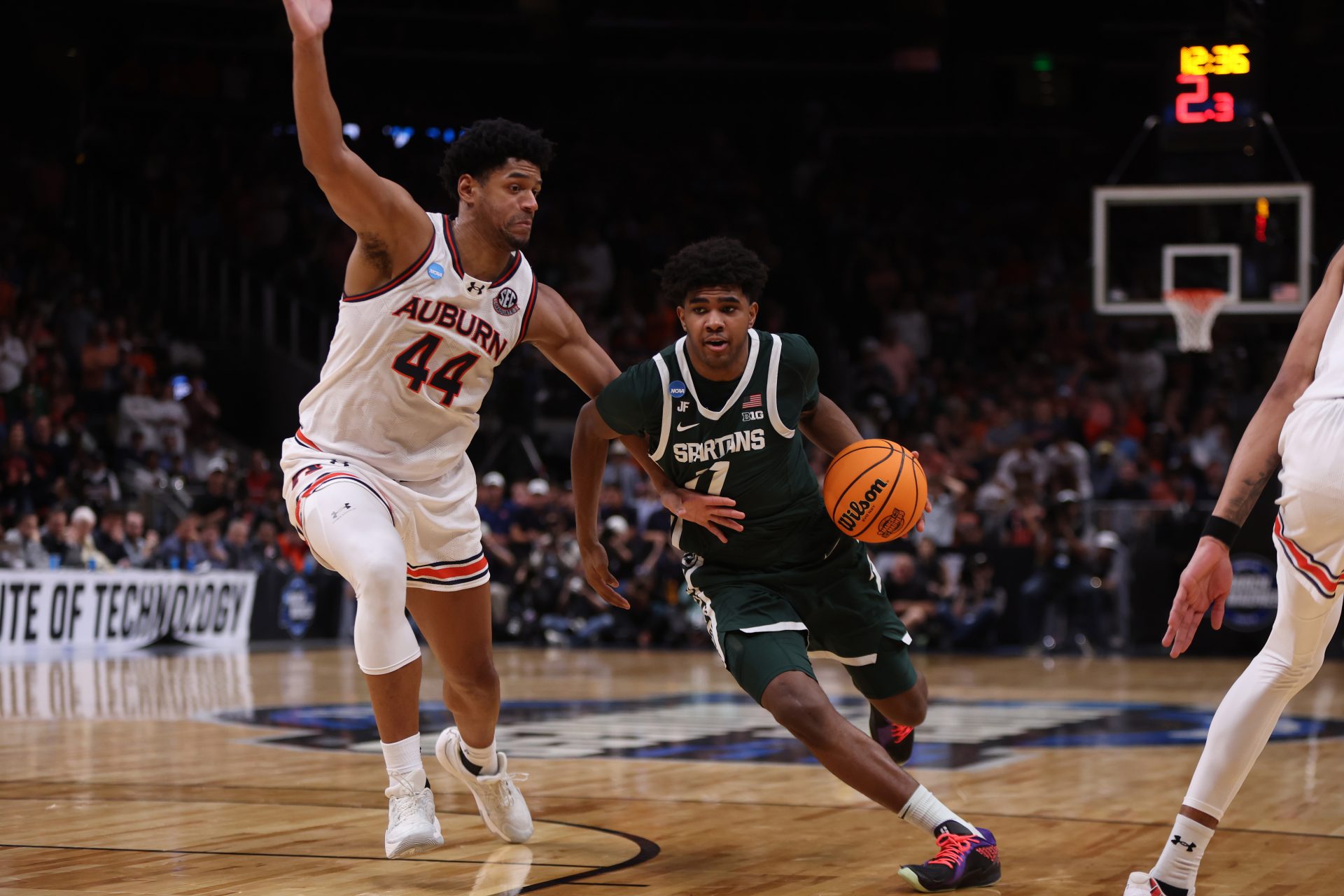 Michigan State Spartans guard Jase Richardson (11) drives against Auburn Tigers center Dylan Cardwell (44) during the second half in the South Regional final of the 2025 NCAA tournament at State Farm Arena.