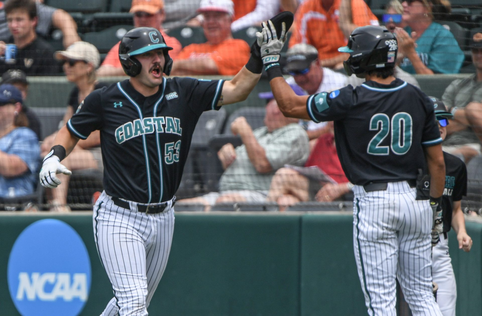 Coastal Carolina junior Derek Bender (53) is congratulated by senior Corey Zientek (20) for scoring during the top of the second inning against Vanderbilt during the NCAA Clemson Regional baseball game at Doug Kingsmore Stadium.