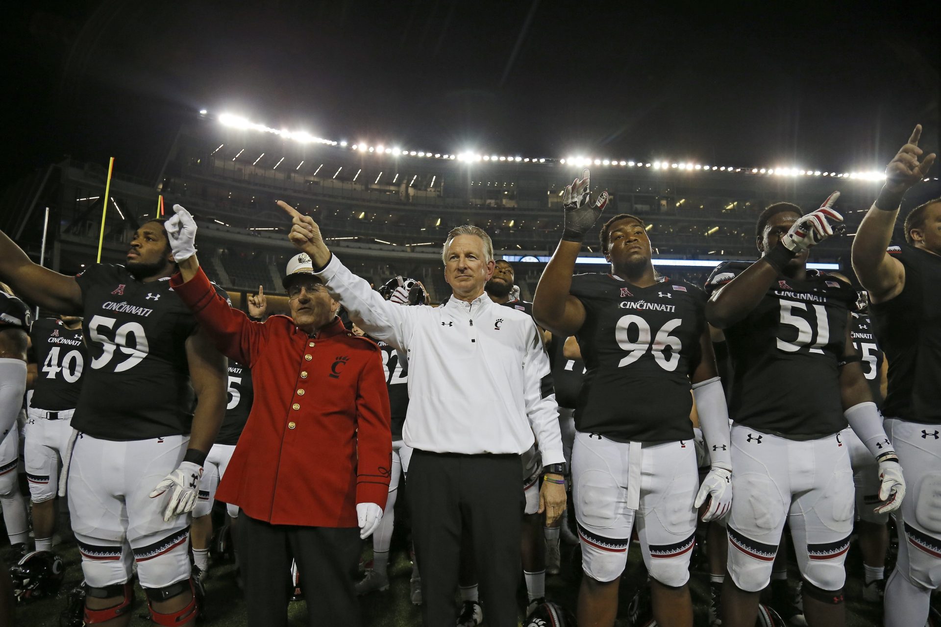 Cincinnati Bearcats head coach Tommy Tuberville and the Bearcats sing the UC alma mater after the NCAA football game between the Cincinnati Bearcats and the South Florida Bulls at Nippert Stadium on the University of Cincinnati campus in Cincinnati on Saturday, Oct. 1, 2016.