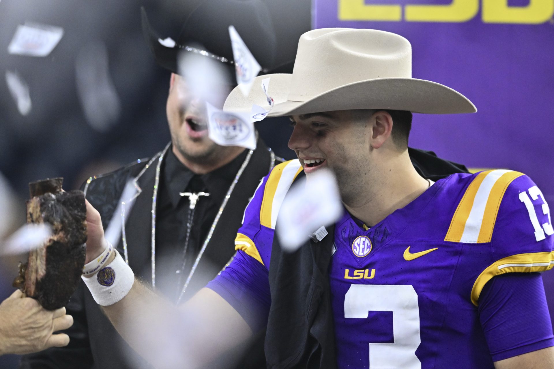 LSU Tigers quarterback Garrett Nussmeier (13) receives a Kinder BBQ rib during the post game celebration at NRG Stadium. The Tigers defeat the Bears 44-31.