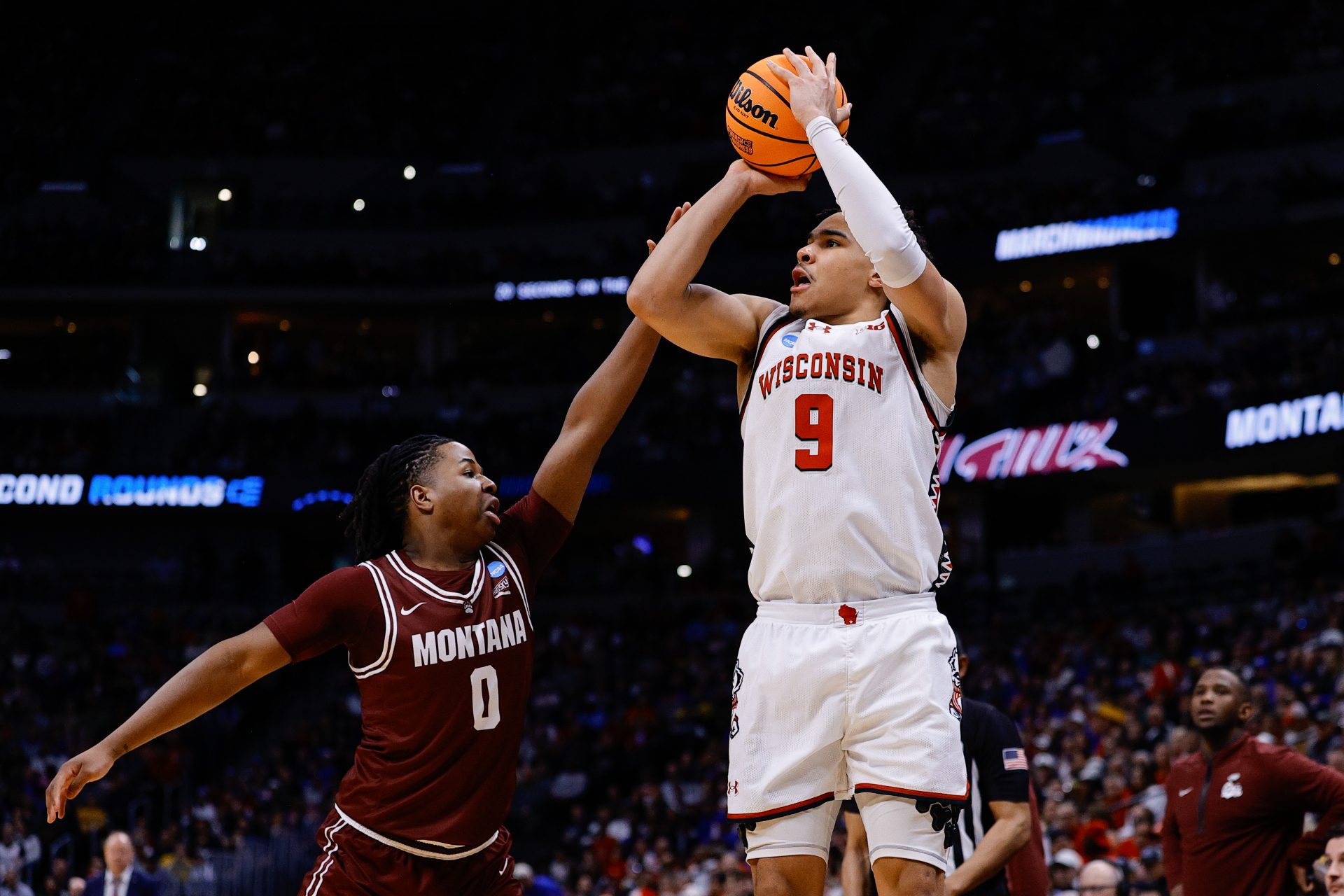 Wisconsin Badgers guard John Tonje (9) shoots the ball against Montana Grizzlies guard Money Williams (0) during the first half in the first round of the NCAA Tournament at Ball Arena.