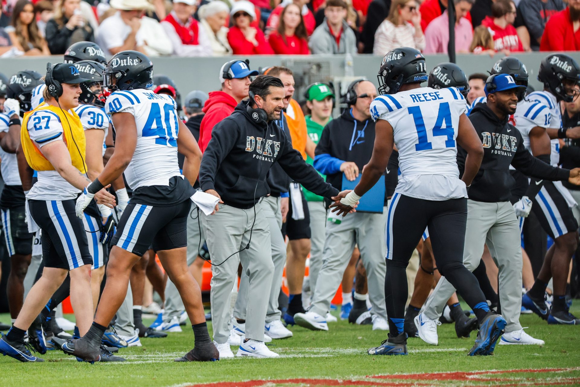 Duke Blue Devils head coach Manny Diaz and defensive end Michael Reese (14) celebrate during the first half of the game against North Carolina State Wolfpack at Carter-Finley Stadium.