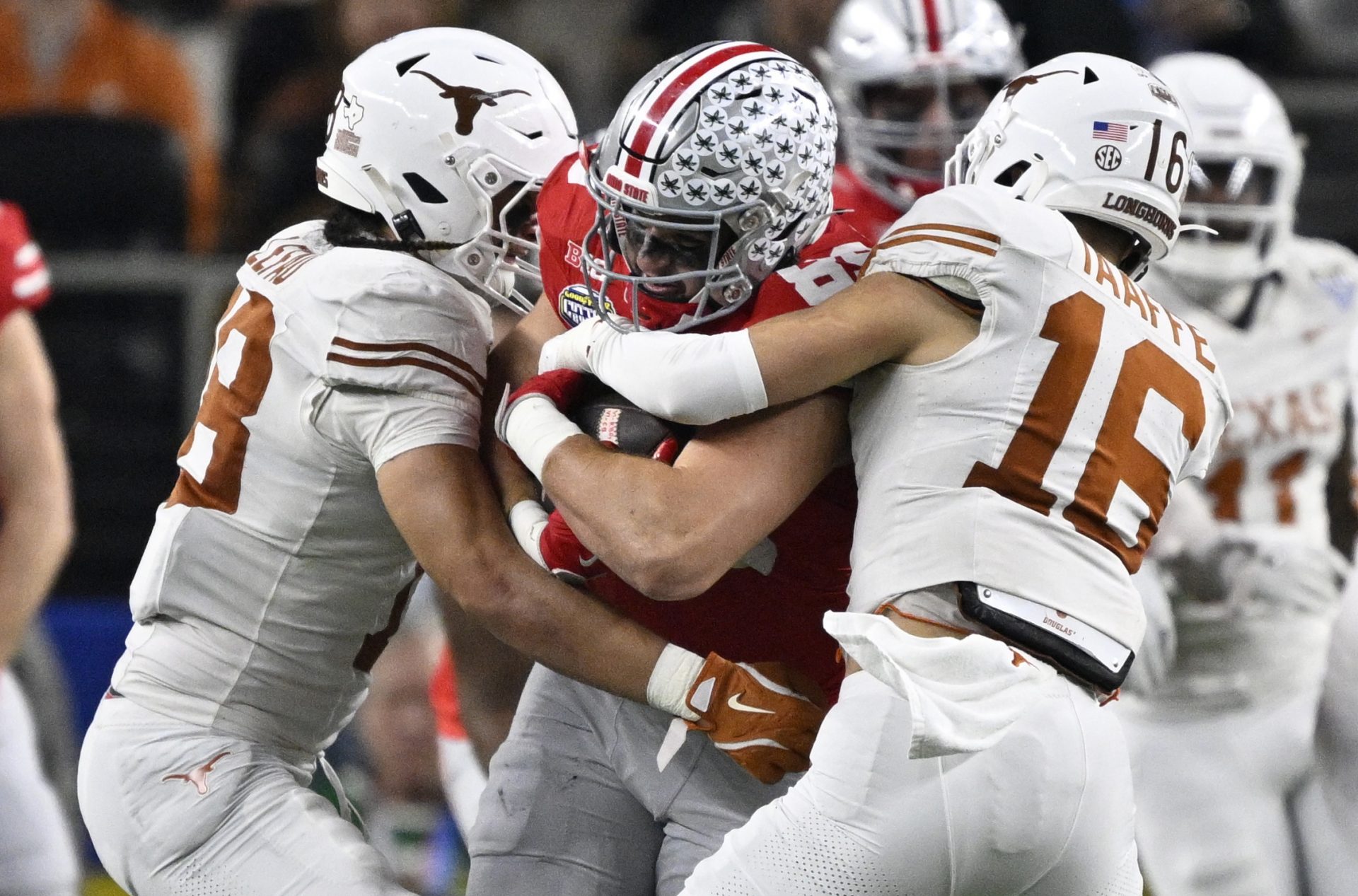 Ohio State Buckeyes tight end Will Kacmarek (89) is tackled by Texas Longhorns linebacker Liona Lefau (18) and defensive back Michael Taaffe (16) during the third quarter of the College Football Playoff semifinal against the Texas Longhorns in the Cotton Bowl at AT&T Stadium.
