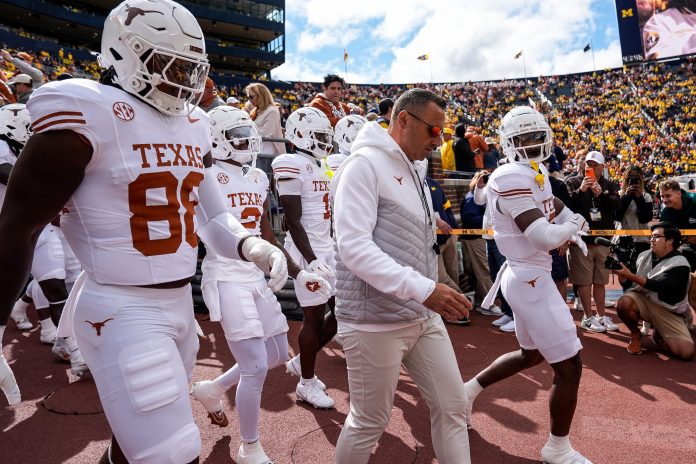 Texas head coach Steve Sarkisian and the Texas players take the field for warm up at Michigan Stadium in Ann Arbor on Saturday, September 7, 2024.