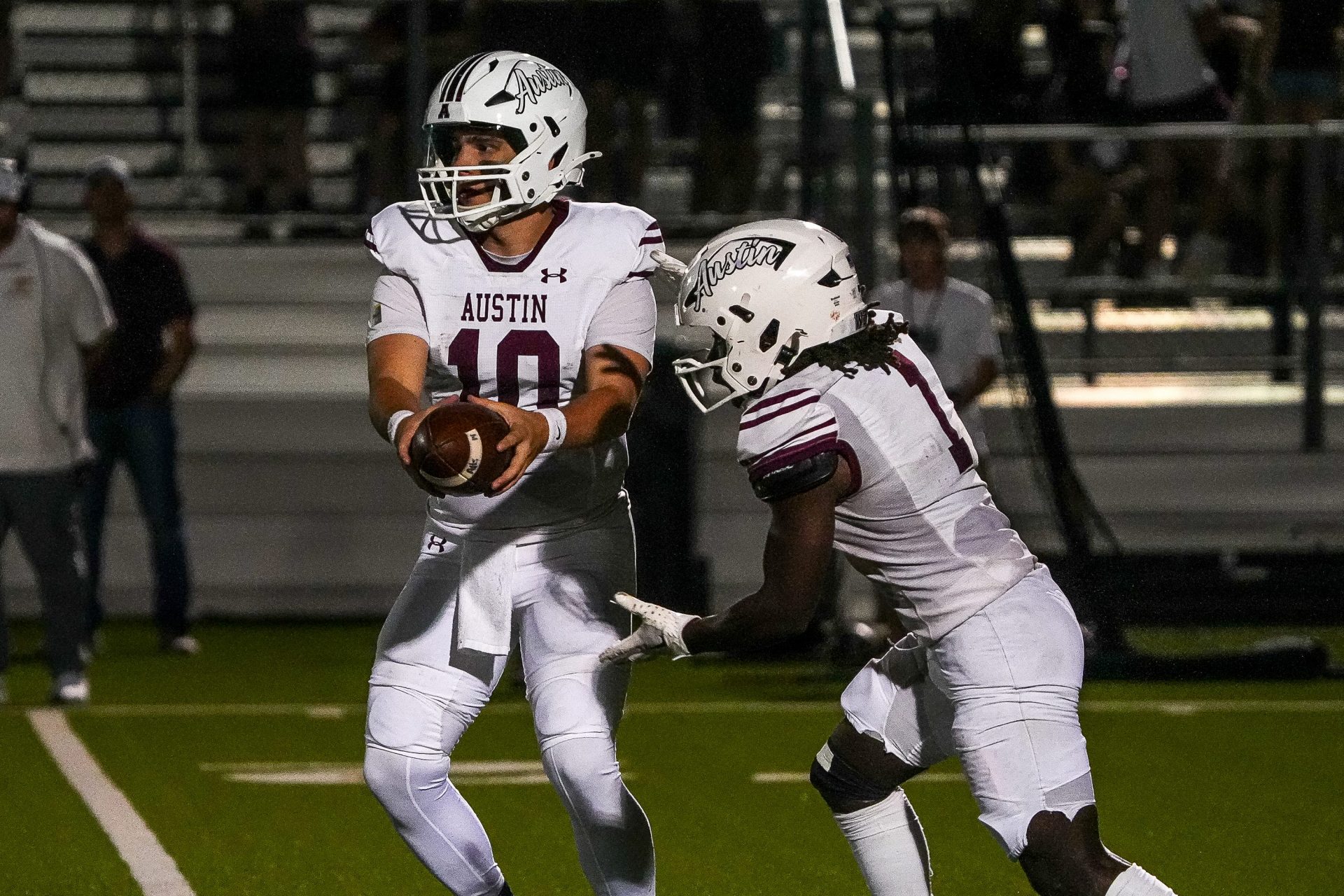 Austin quarterback John Latham (10) hands the ball off to Bryson Batts (1) during the game against Dripping Springs at Dripping Springs High School on Friday, October. 4, 2024 in Dripping Springs, Texas.