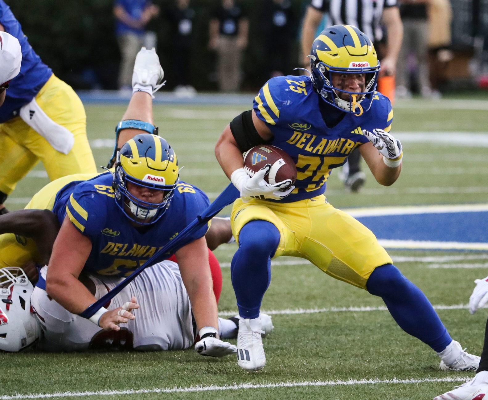 Delaware running back Kaelin Costello tears his jersey but gains ground in front of lineman Steven Demboski in the fourth quarter of the Blue Hens' 49-0 win at Delaware Stadium, Saturday, Sept. 28, 2024.
