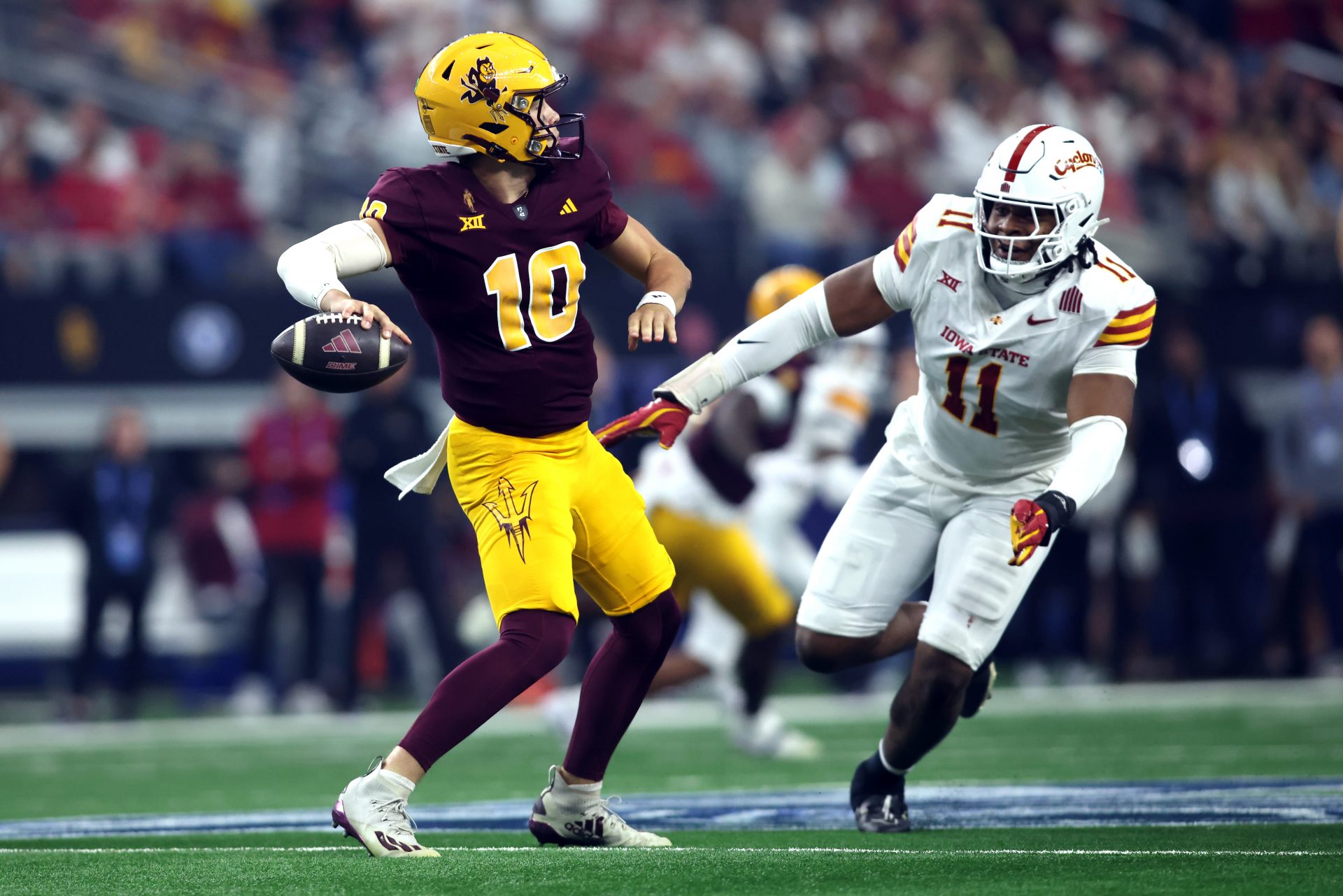 Arizona State Sun Devils quarterback Sam Leavitt (10) throws a pass against Iowa State Cyclones defensive end Tyler Onyedim (11) in the second quarter at AT&T Stadium.