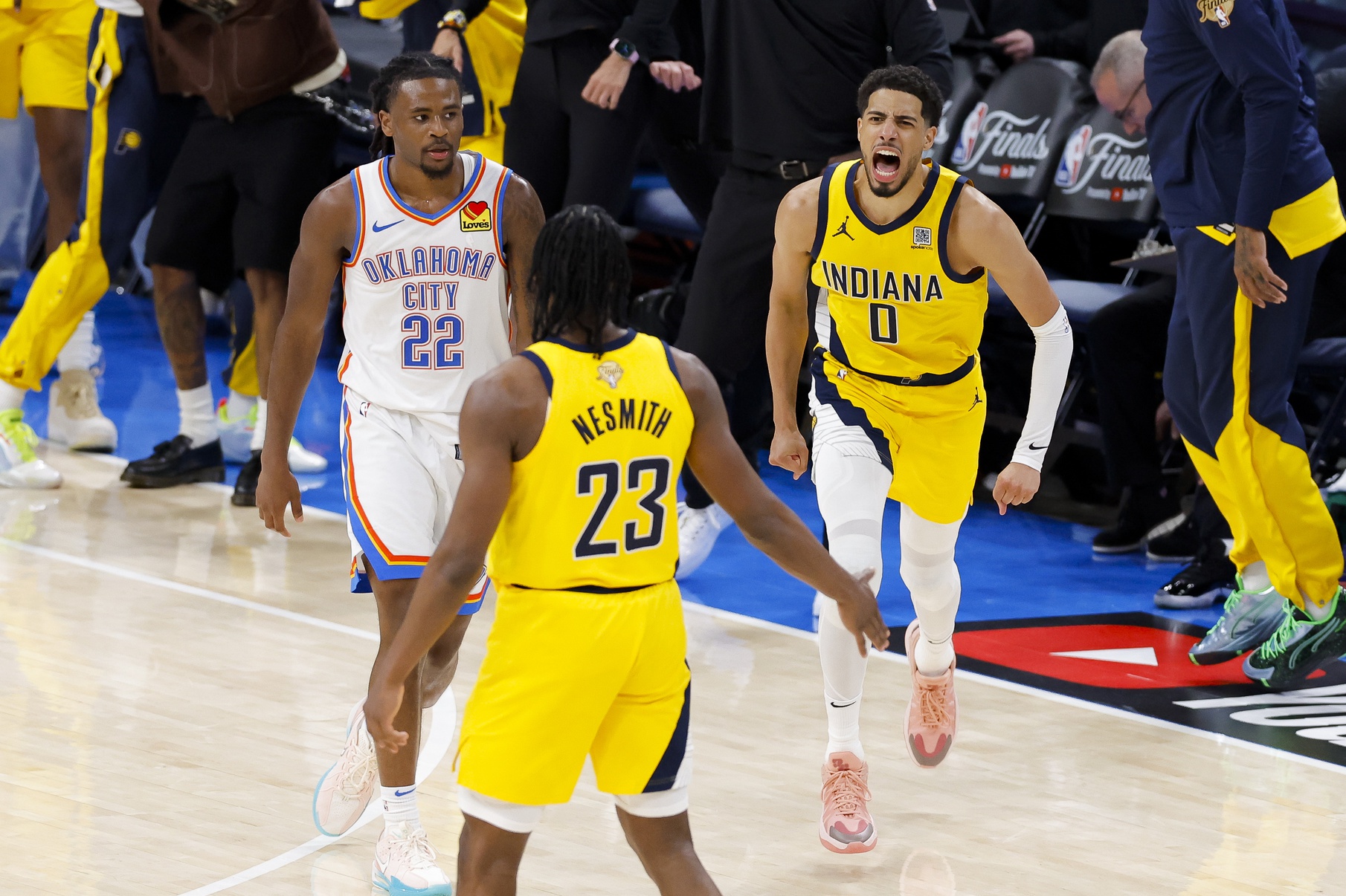Indiana Pacers guard Tyrese Haliburton (0) and forward Aaron Nesmith (23) celebrate after Haliburton makes the game winning shot as Oklahoma City Thunder guard Cason Wallace (22) looks on during the fourth quarter during game one of the 2025 NBA Finals at Paycom Center.