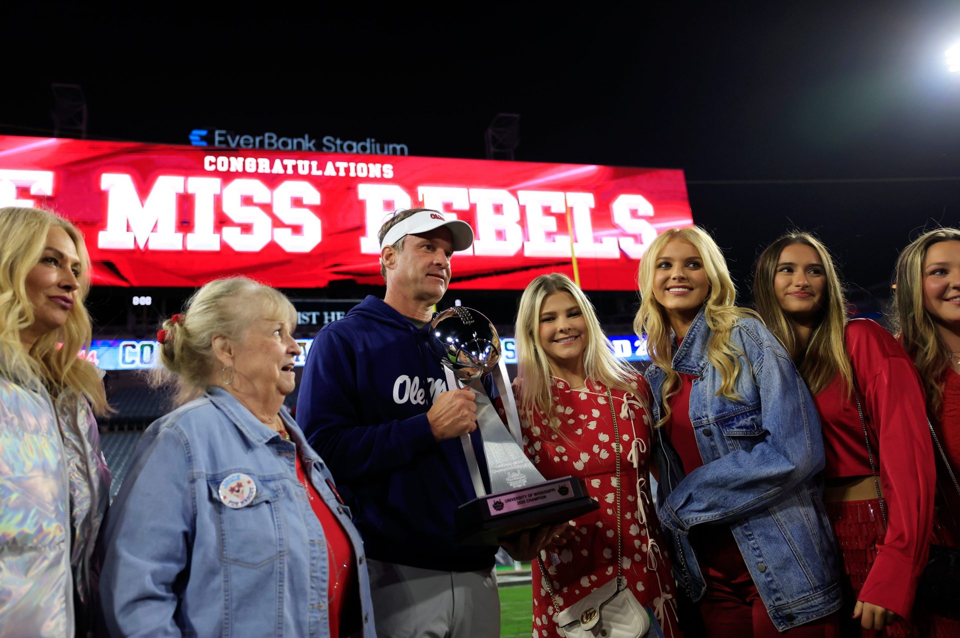 Mississippi Rebels head coach Lane Kiffin, center left, poses with the Ash Verlander Champions Trophy with his family after the game of the TaxSlayer Gator Bowl Thursday, Jan. 2, 2025 at EverBank Stadium in Jacksonville, Fla. Ole Miss defeated Duke 52-20. [Corey Perrine/Florida Times-Union]
