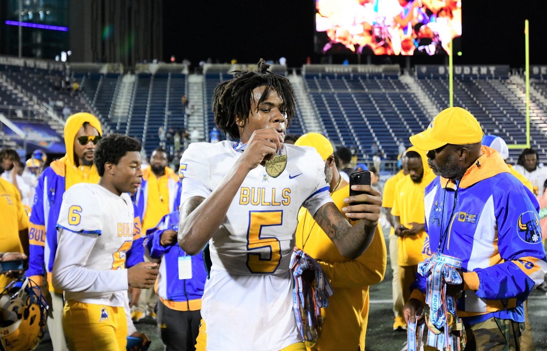Miami Northwestern's Calvin Russell Jr. takes a selfie with his state medal after his team won the Class 3A championship against Raines on Dec. 14, 2024.