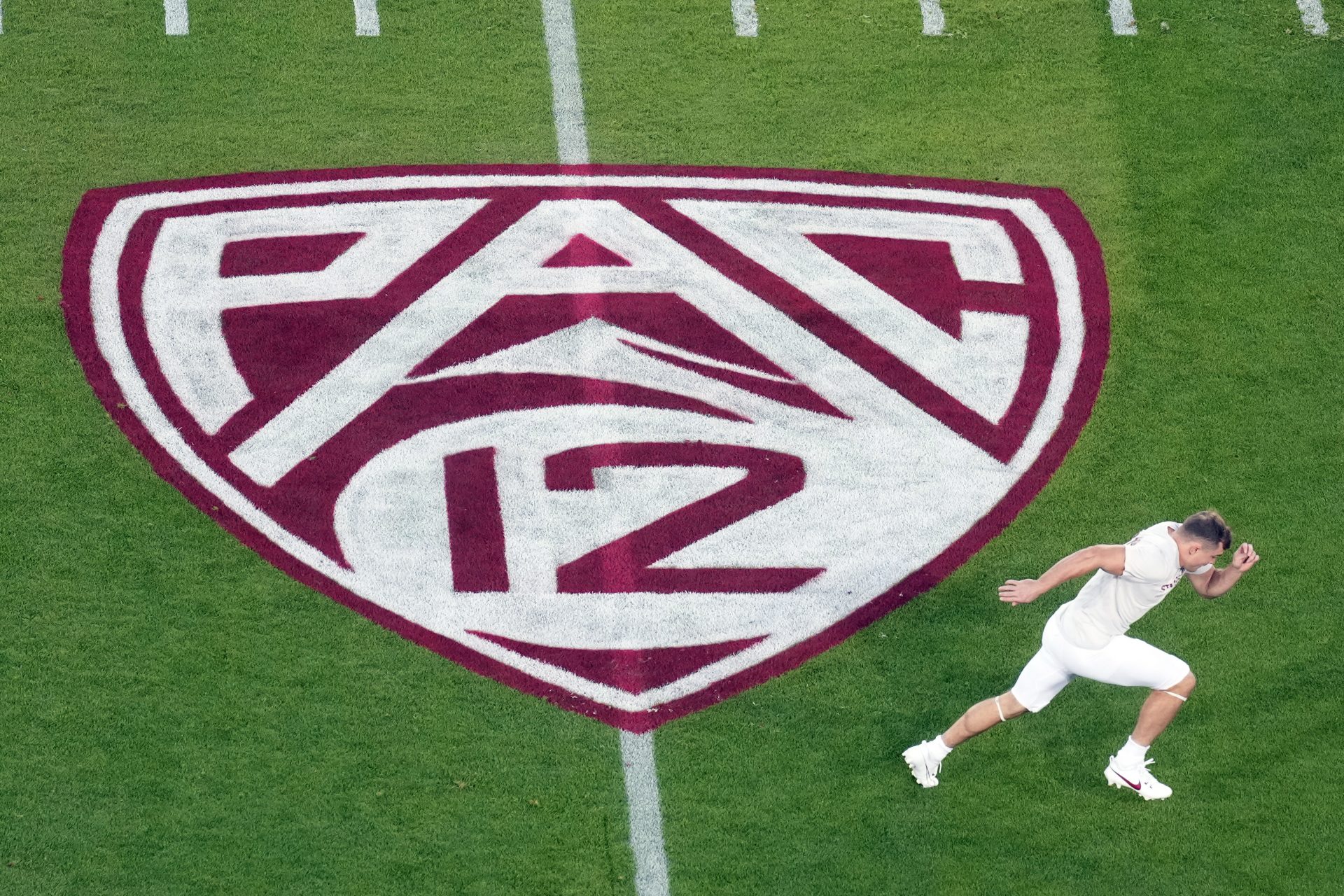 A view of the Pac-12 logo on the field as Stanford Cardinal wide receiver David Kasemervisz (80) warms up before the game against the UCLA Bruins at Stanford Stadium.