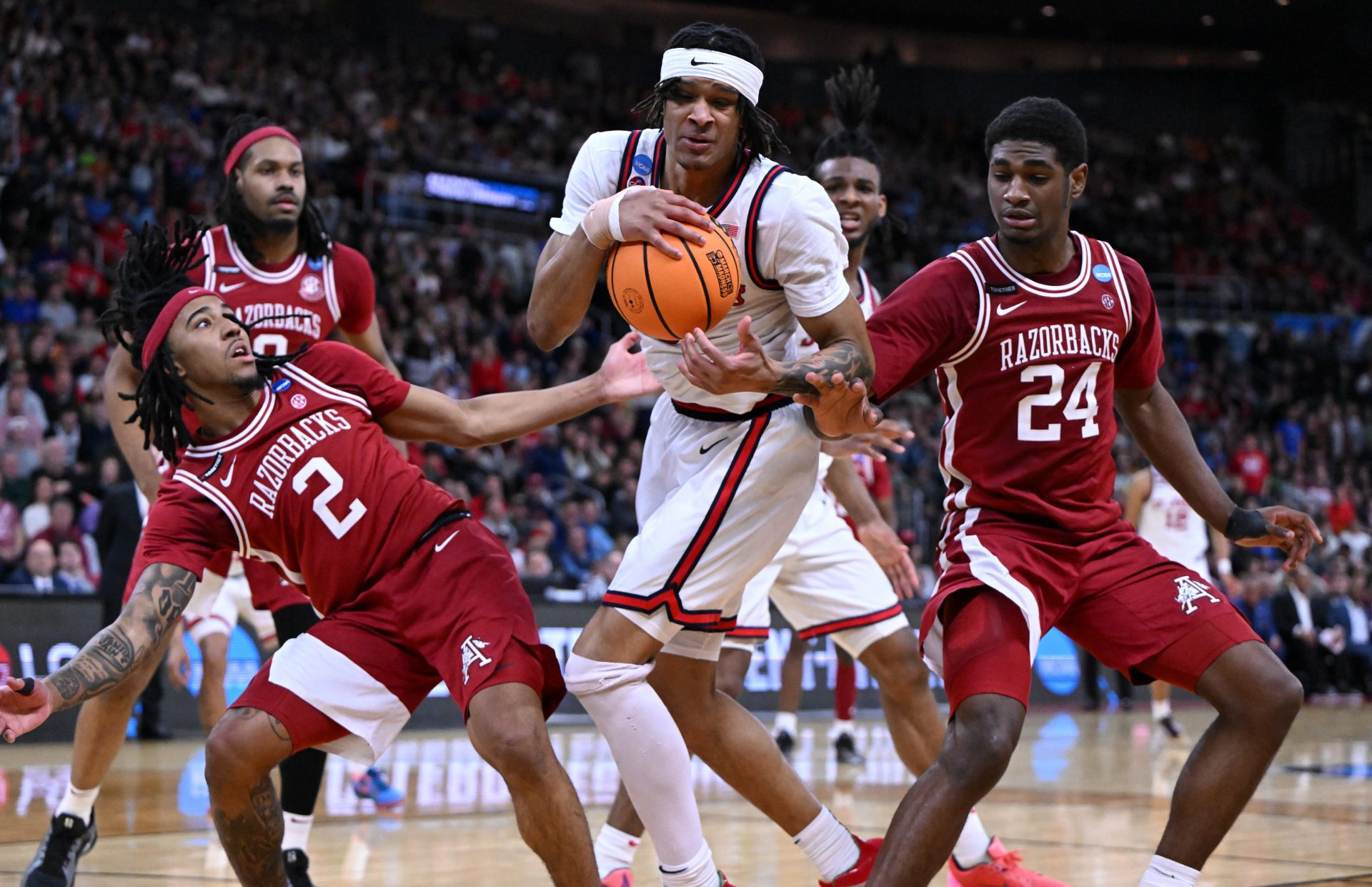 Arkansas Razorbacks guard Boogie Fland (2) and forward Billy Richmond III (24) fight for a rebound against St. John's Red Storm guard Aaron Scott (0) during the second half of a second round men’s NCAA Tournament game at Amica Mutual Pavilion.