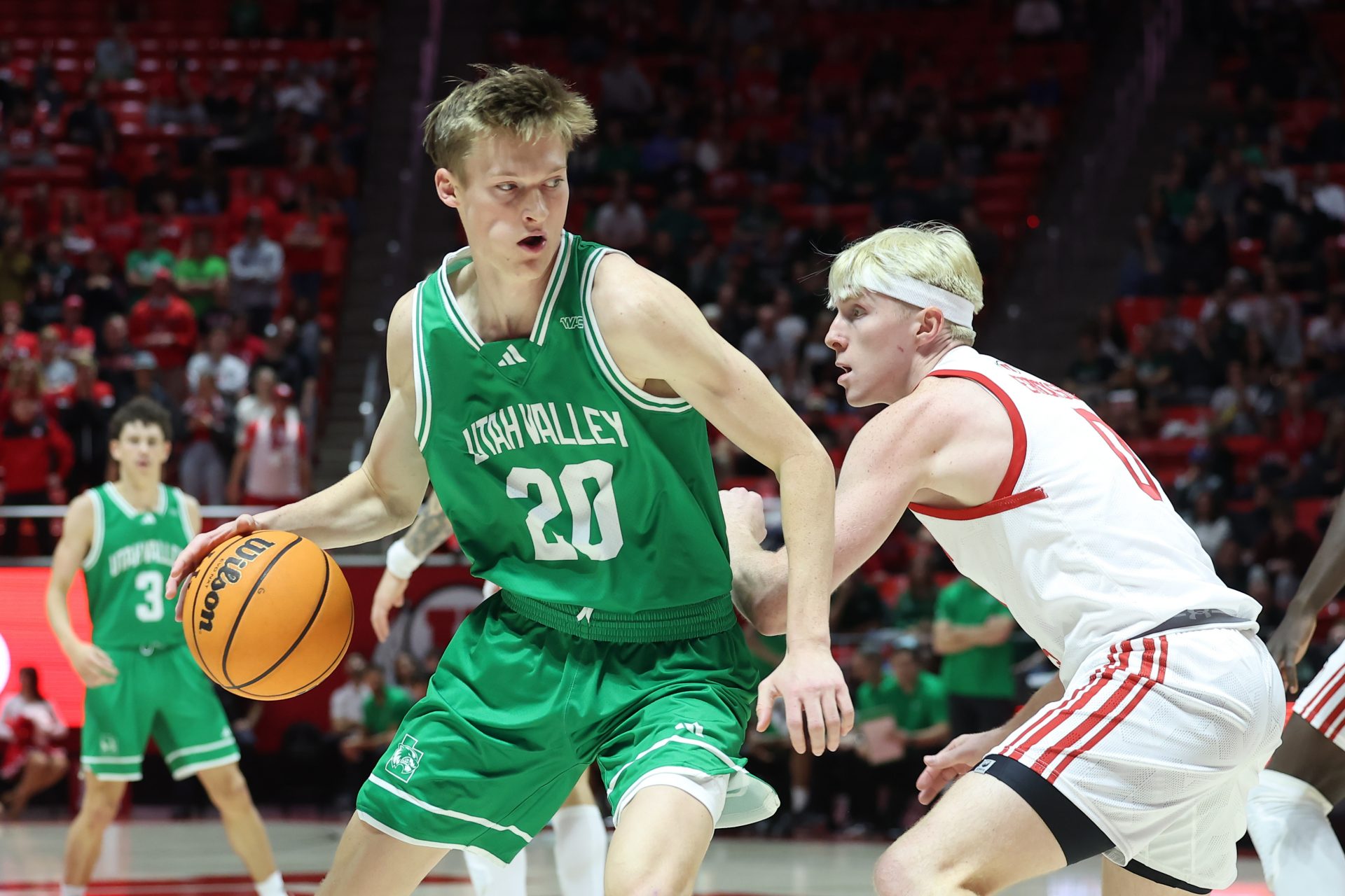 Utah Valley Wolverines guard Trevan Leonhardt (20) dribbles the ball defended by Utah Utes guard Hunter Erickson (0) during the first half at Jon M. Huntsman Center.