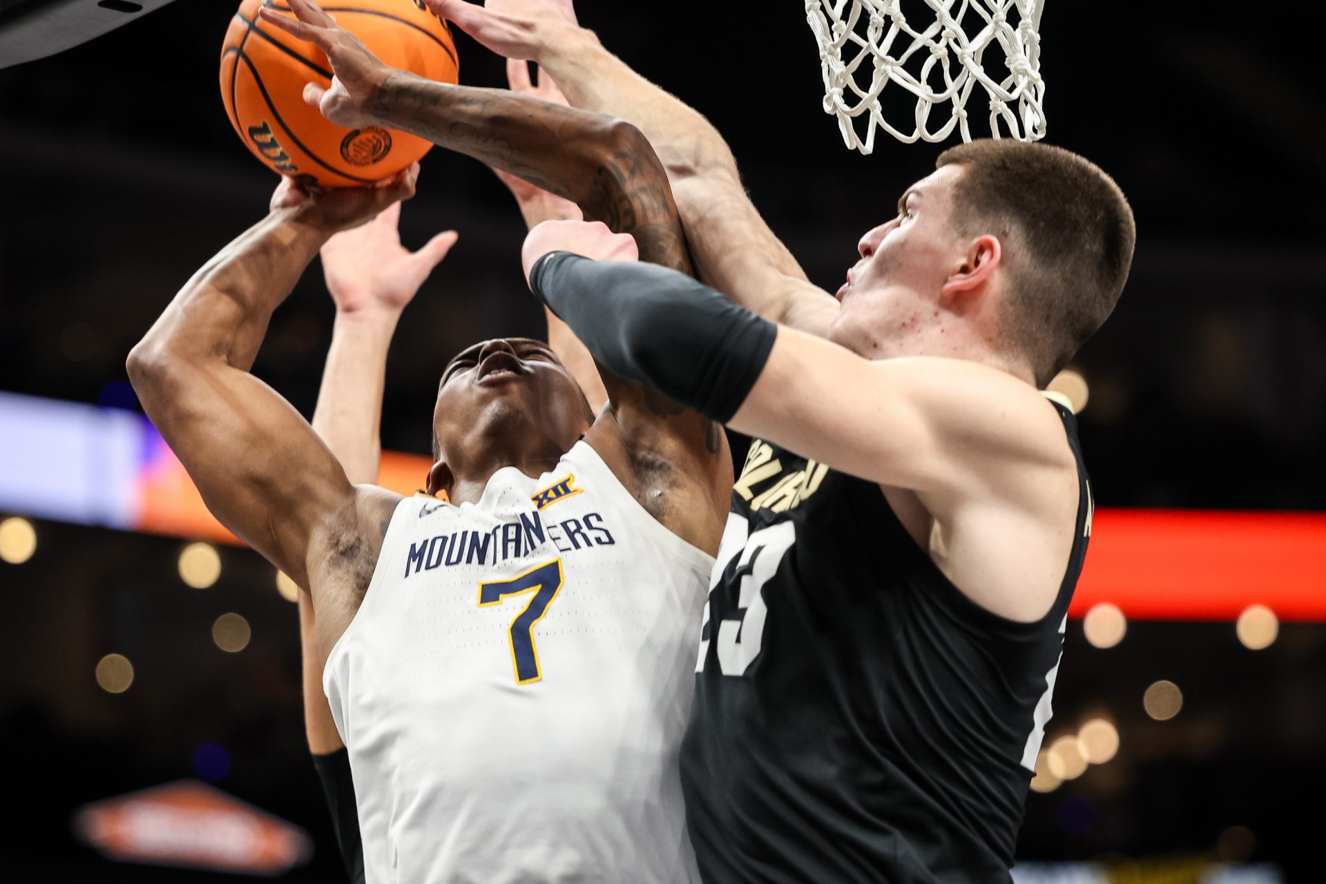 West Virginia Mountaineers guard Javon Small (7) and Colorado Buffaloes forward Andrej Jakimovski (23) collide under the basket during the first half at T-Mobile Center.