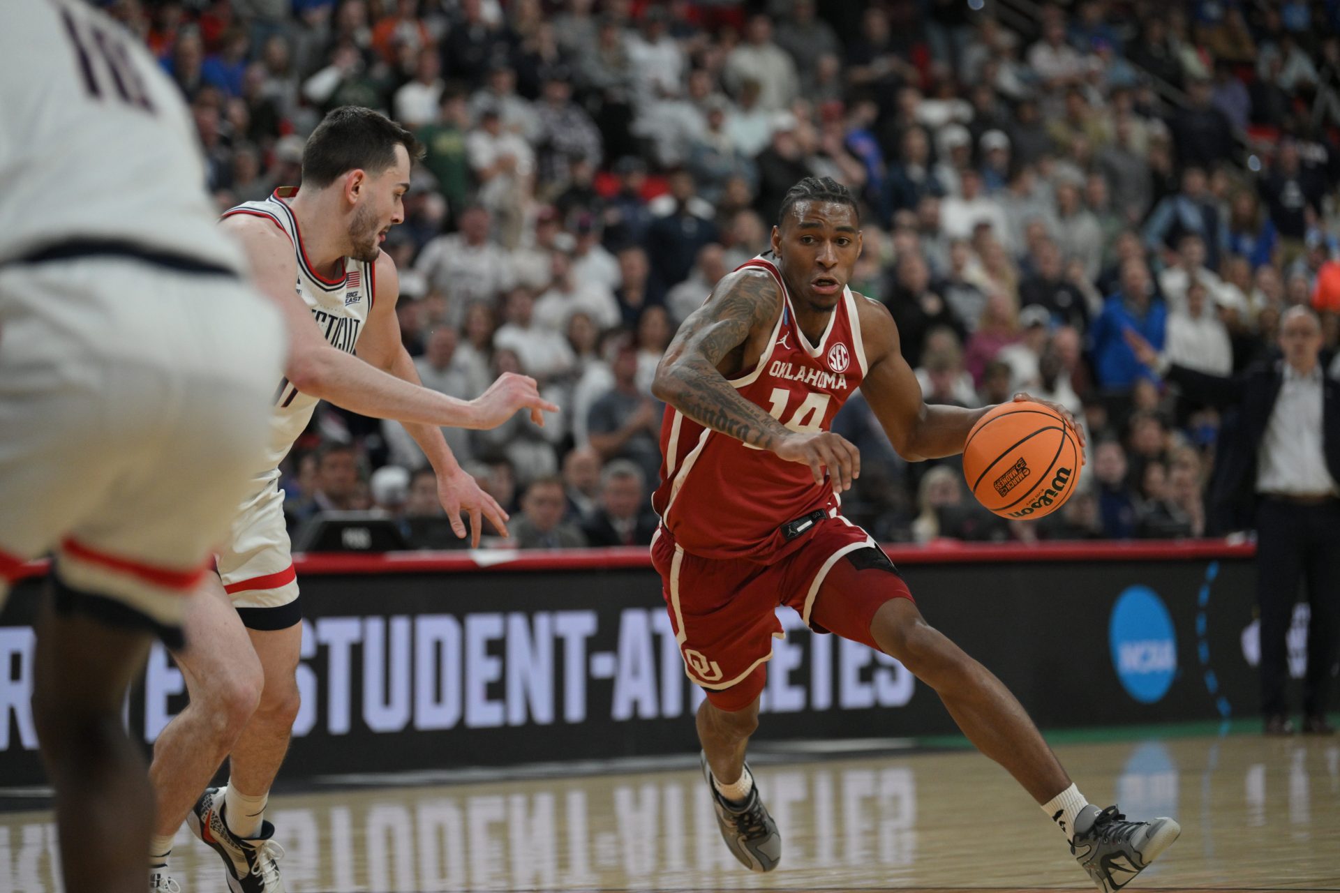 Oklahoma Sooners forward Jalon Moore (14) drives around Connecticut Huskies forward Alex Karaban (11) during the second half at Lenovo Center.