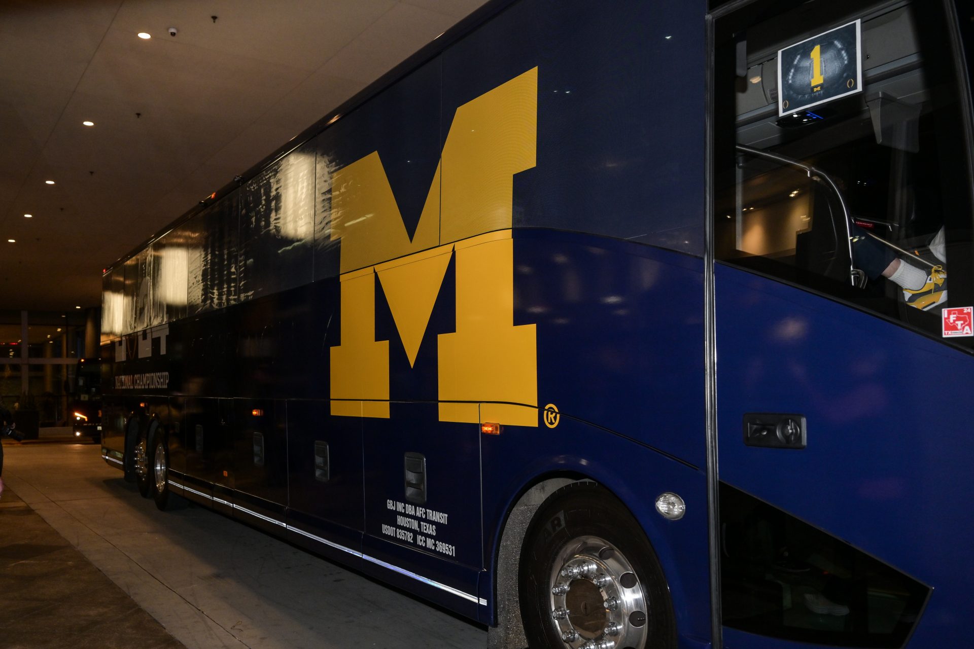 A detailed view of the Michigan Wolverines bus arriving at Hilton Americas.