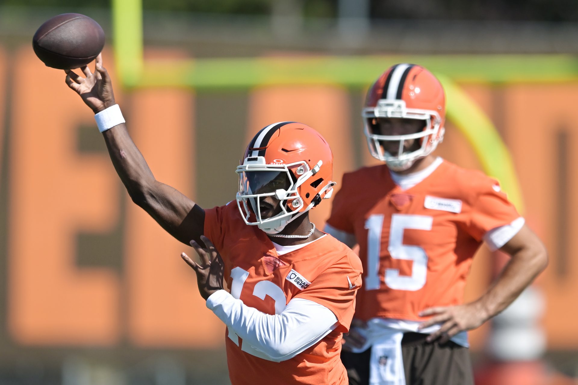 Cleveland Browns quarterback Shedeur Sanders (12) throws a pass as quarterback Joe Flacco (15) looks on during training camp at CrossCountry Mortgage Campus.